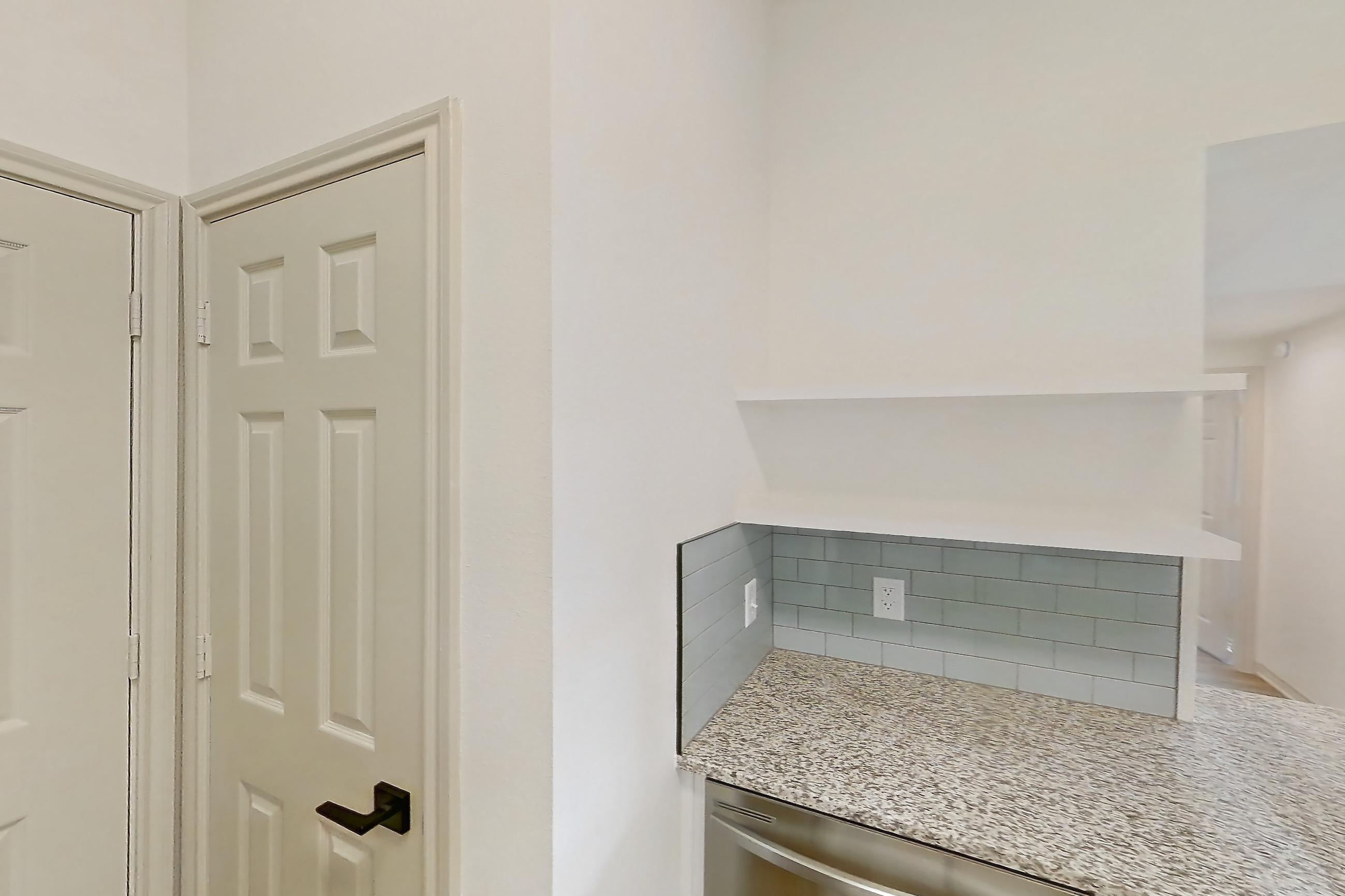 Kitchen with dishwasher, electric range, light countertops, light stone countertops, light wood-finish flooring, microwave, oven/range, and stainless steel appliances, Apartment 2306 at Cortland Wortham