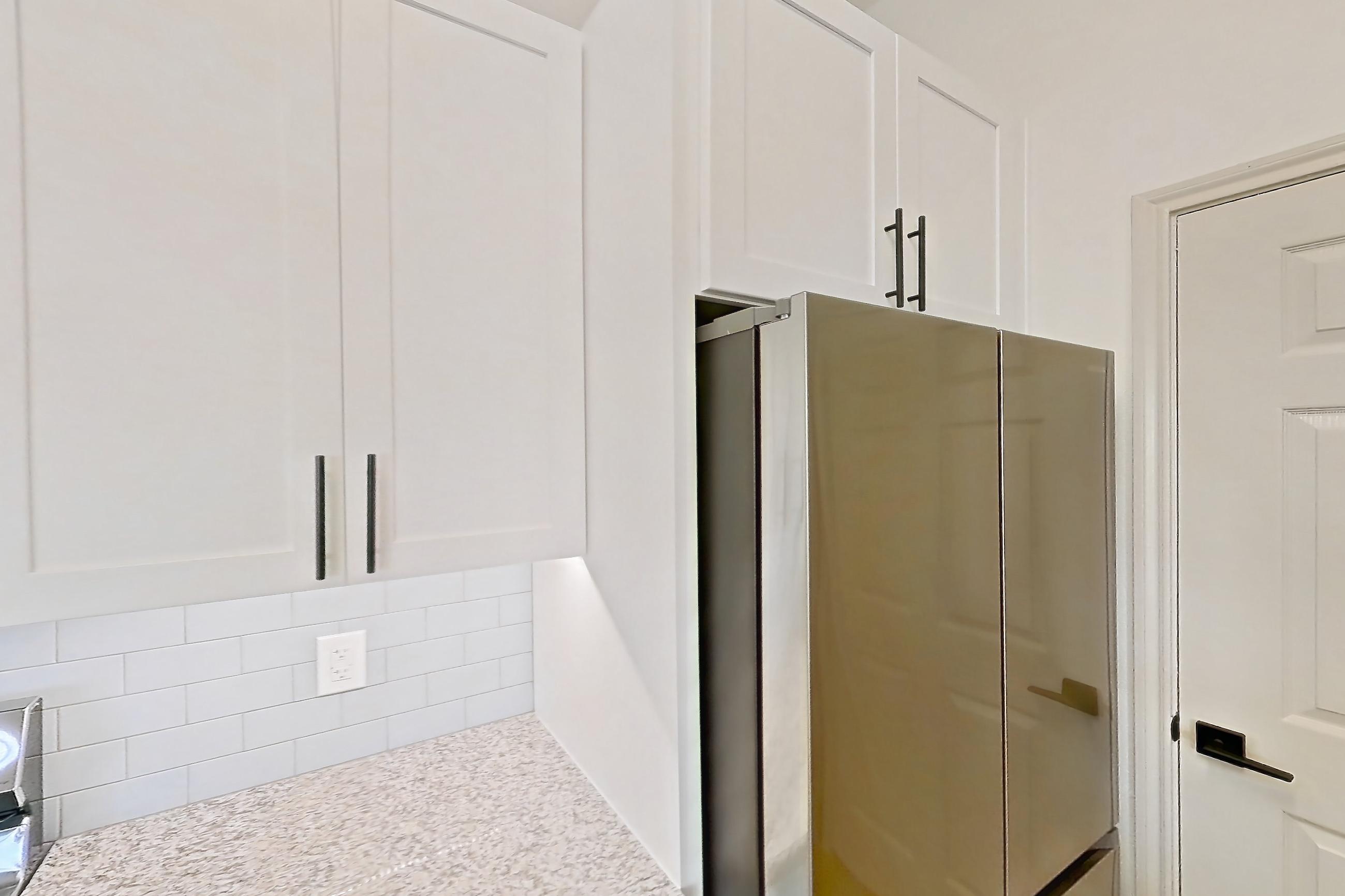 Kitchen with dishwasher, electric range, light countertops, light stone countertops, light wood-finish flooring, microwave, oven/range, and stainless steel appliances, Apartment 2306 at Cortland Wortham