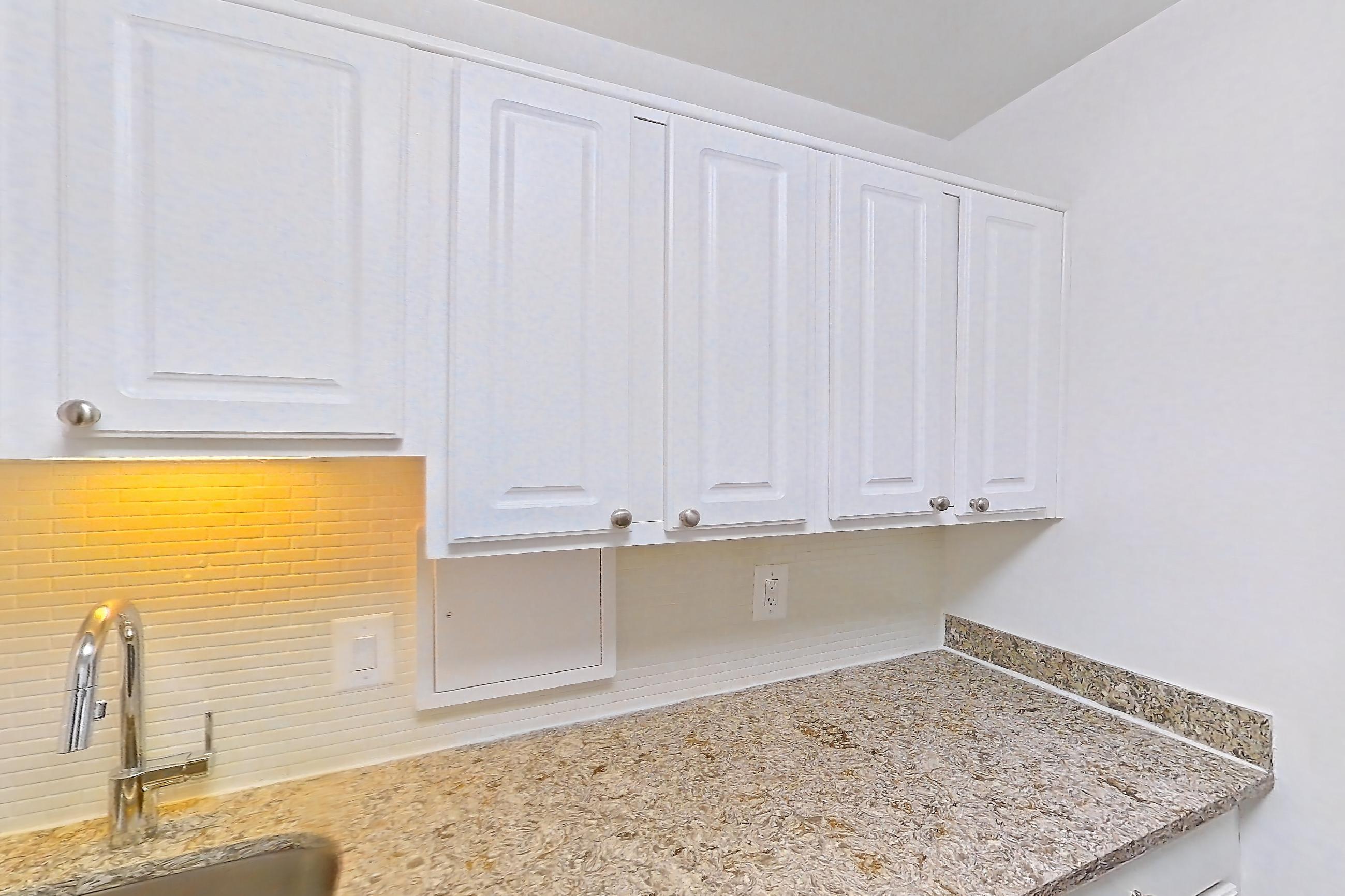 Kitchen with dark wood-finish flooring, dishwasher, gas range, light countertops, light stone countertops, microwave, oven/range, refrigerator, and stainless steel appliances, Apartment S-803 at Cortland on Pike