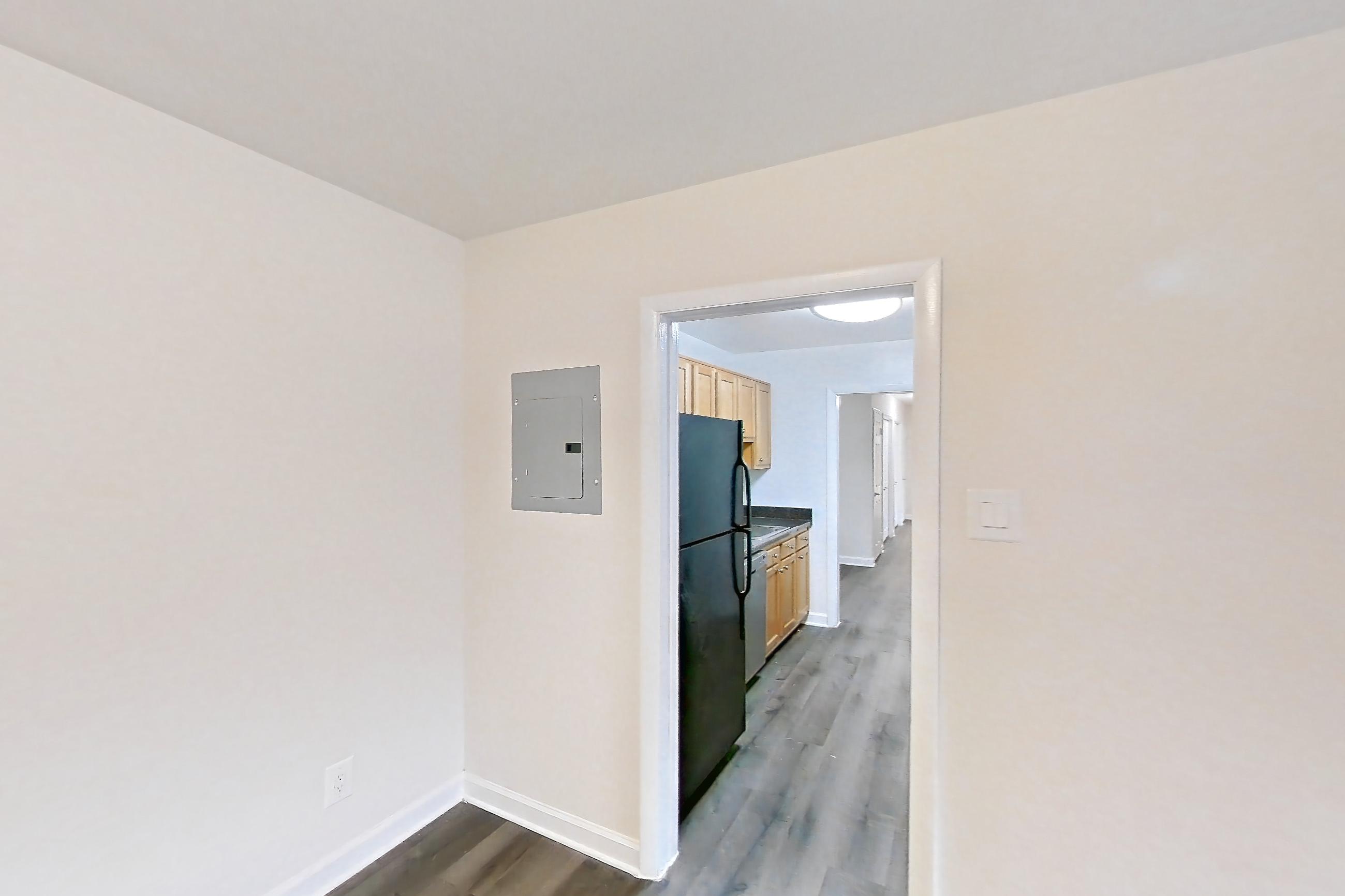 Dining room with dark wood-finish flooring and refrigerator, Apartment C-402 at Cortland on Pike