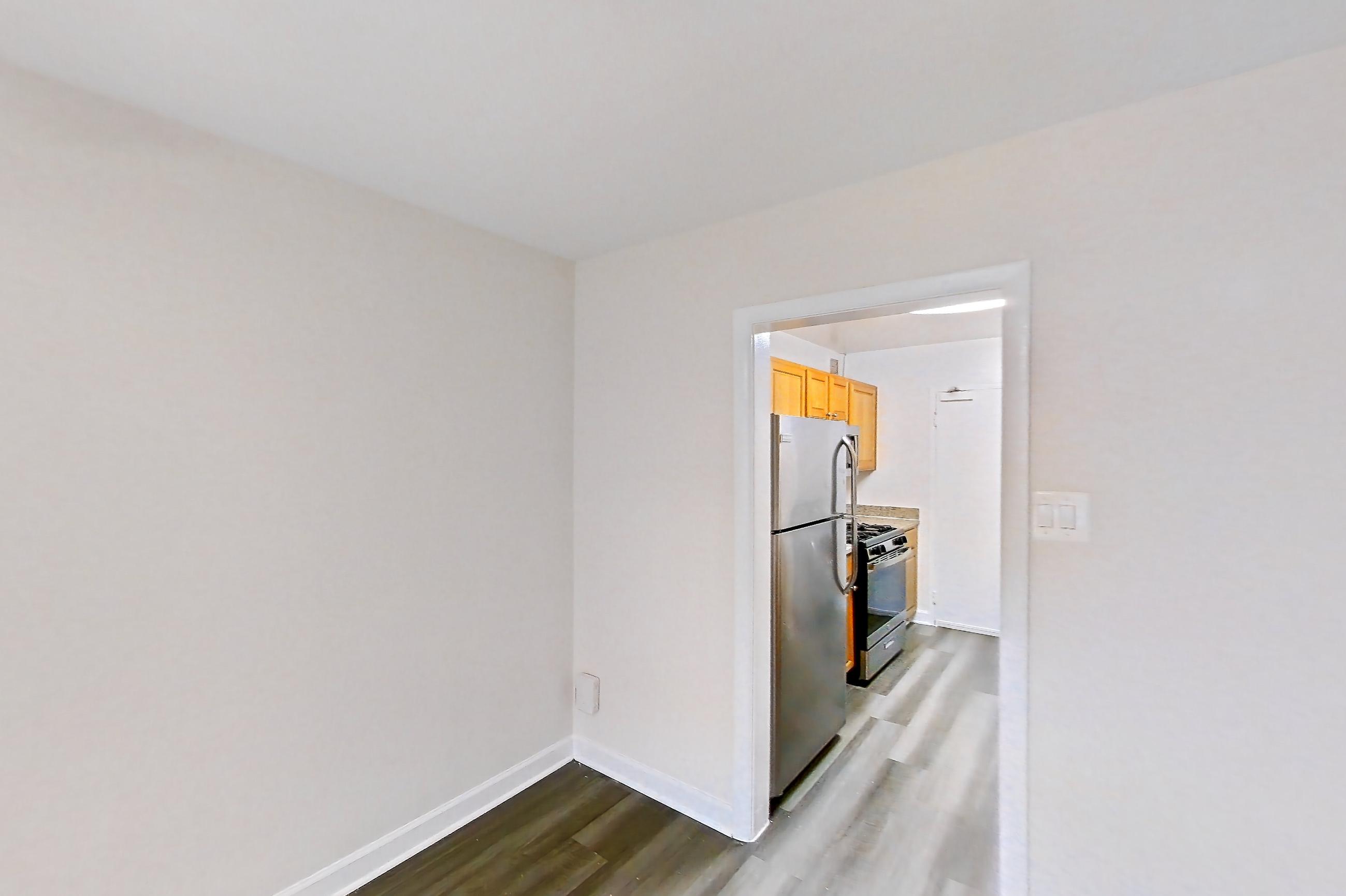 Dining room with dark wood-finish flooring, gas range, oven/range, refrigerator, and stainless steel appliances, Apartment C-209 at Cortland on Pike