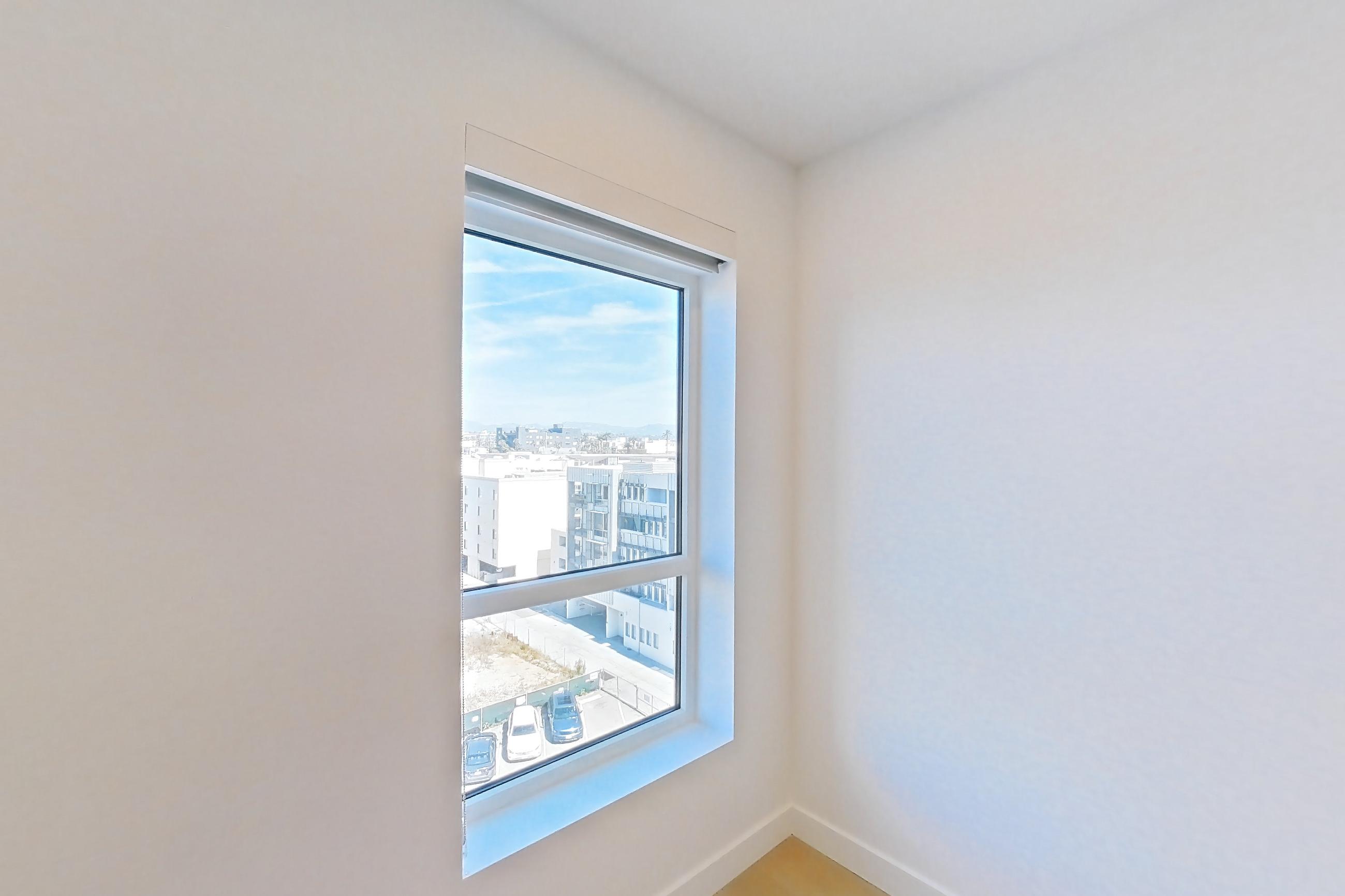 Living room with city view and light wood-finish flooring, Apartment B-707 at Santa Monica Collection