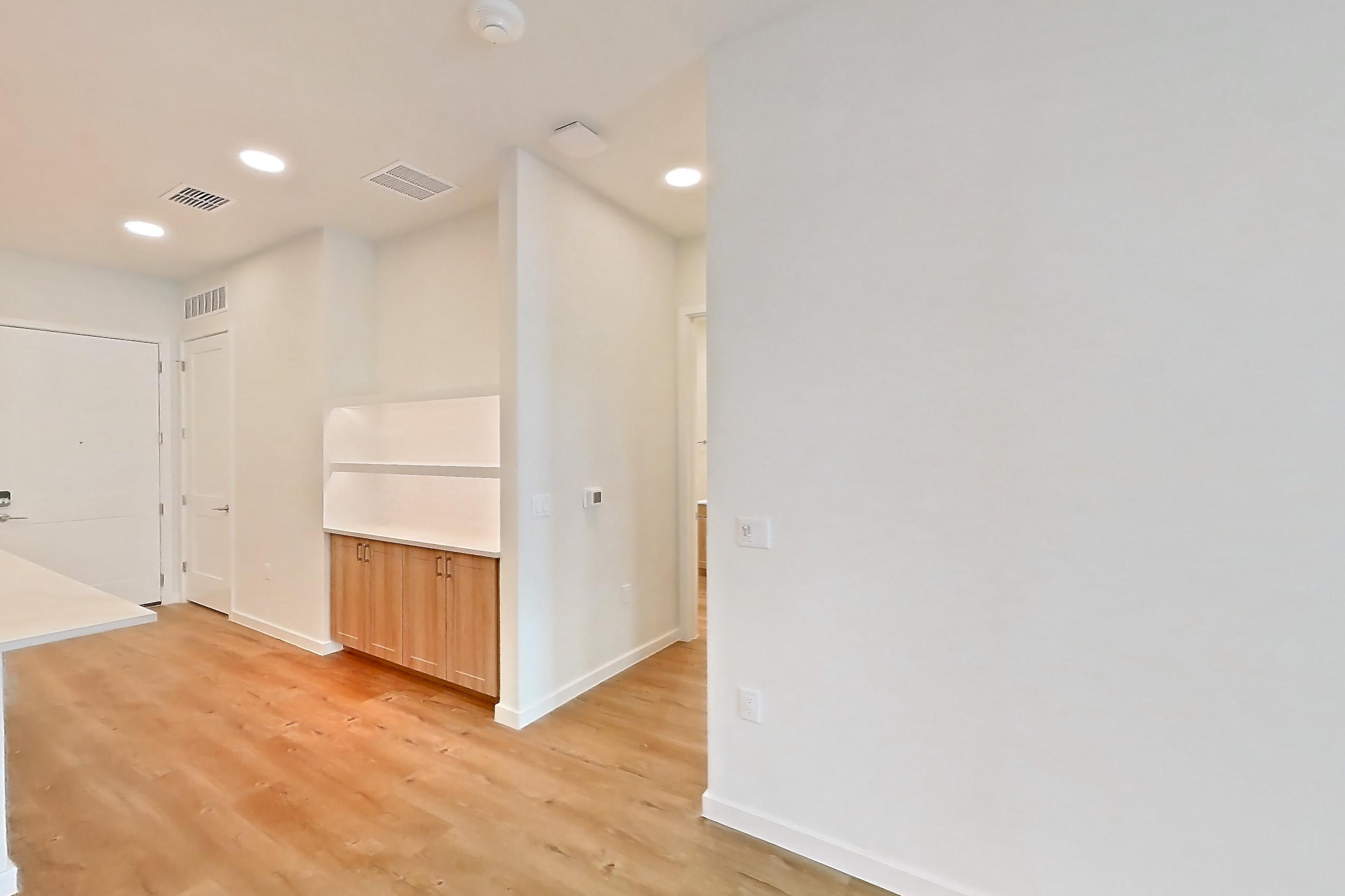 Living space with dishwasher, electric range, light countertops, light wood-finish flooring, oven/range, refrigerator, and stainless steel appliances, Apartment 156 at Lantower Bayside
