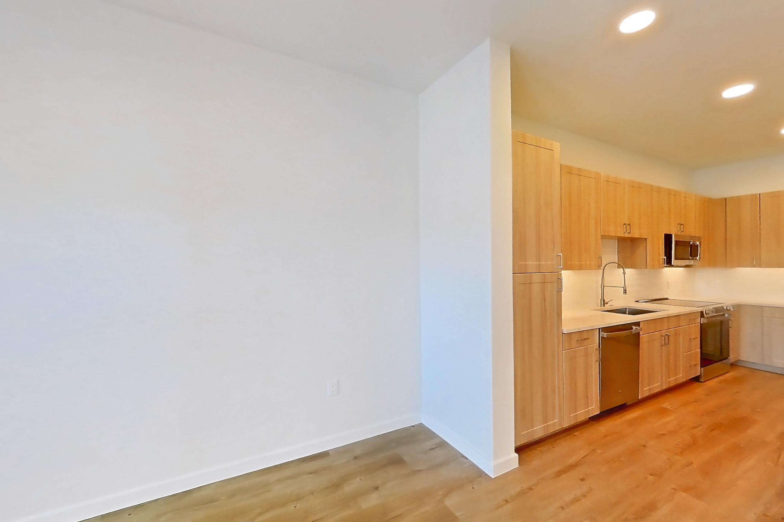 Living space with dishwasher, electric range, light countertops, light wood-finish flooring, oven/range, refrigerator, and stainless steel appliances, Apartment 233 at Lantower Bayside
