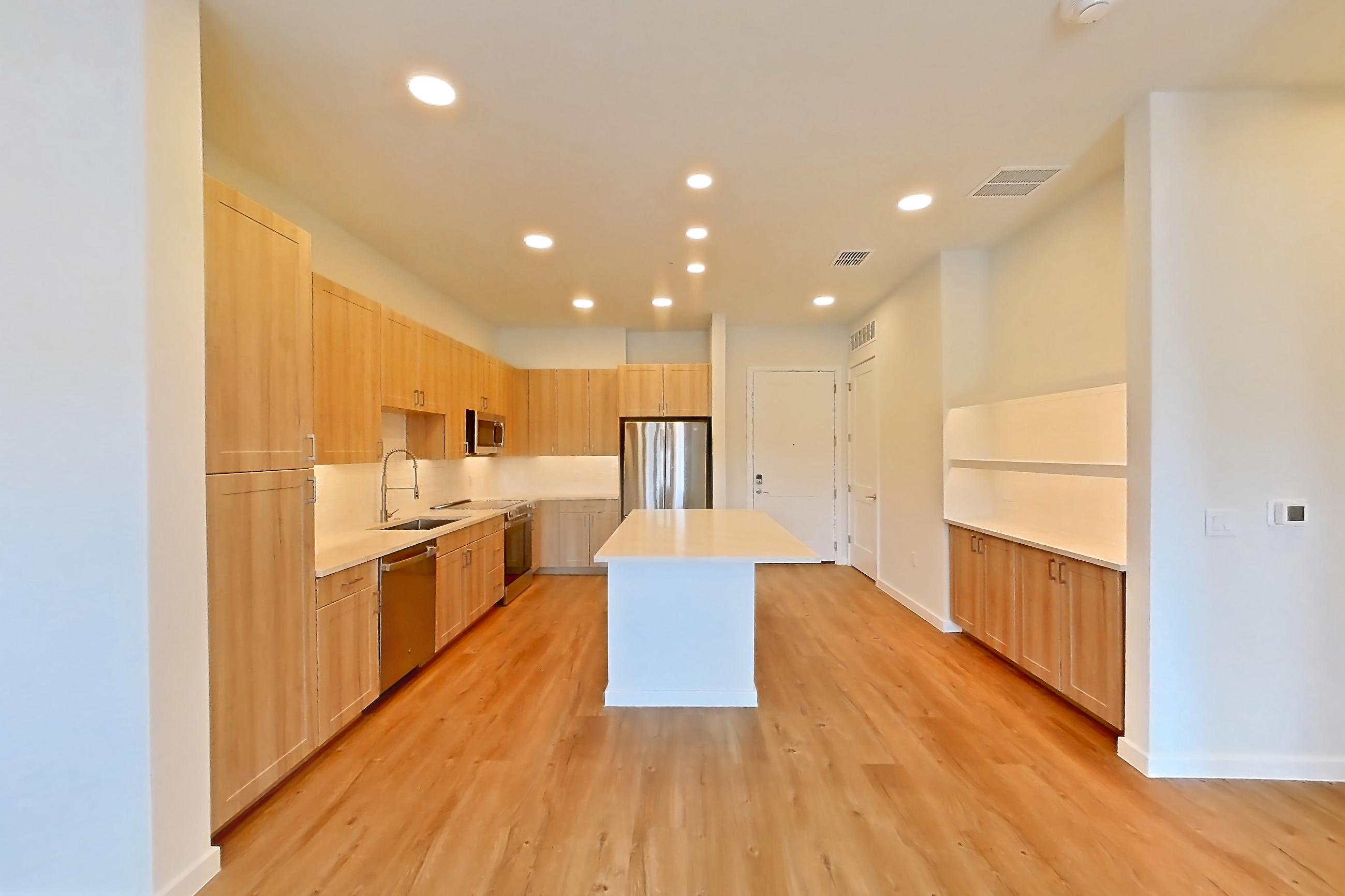 Living space with dishwasher, electric range, light countertops, light wood-finish flooring, oven/range, refrigerator, and stainless steel appliances, Apartment 233 at Lantower Bayside