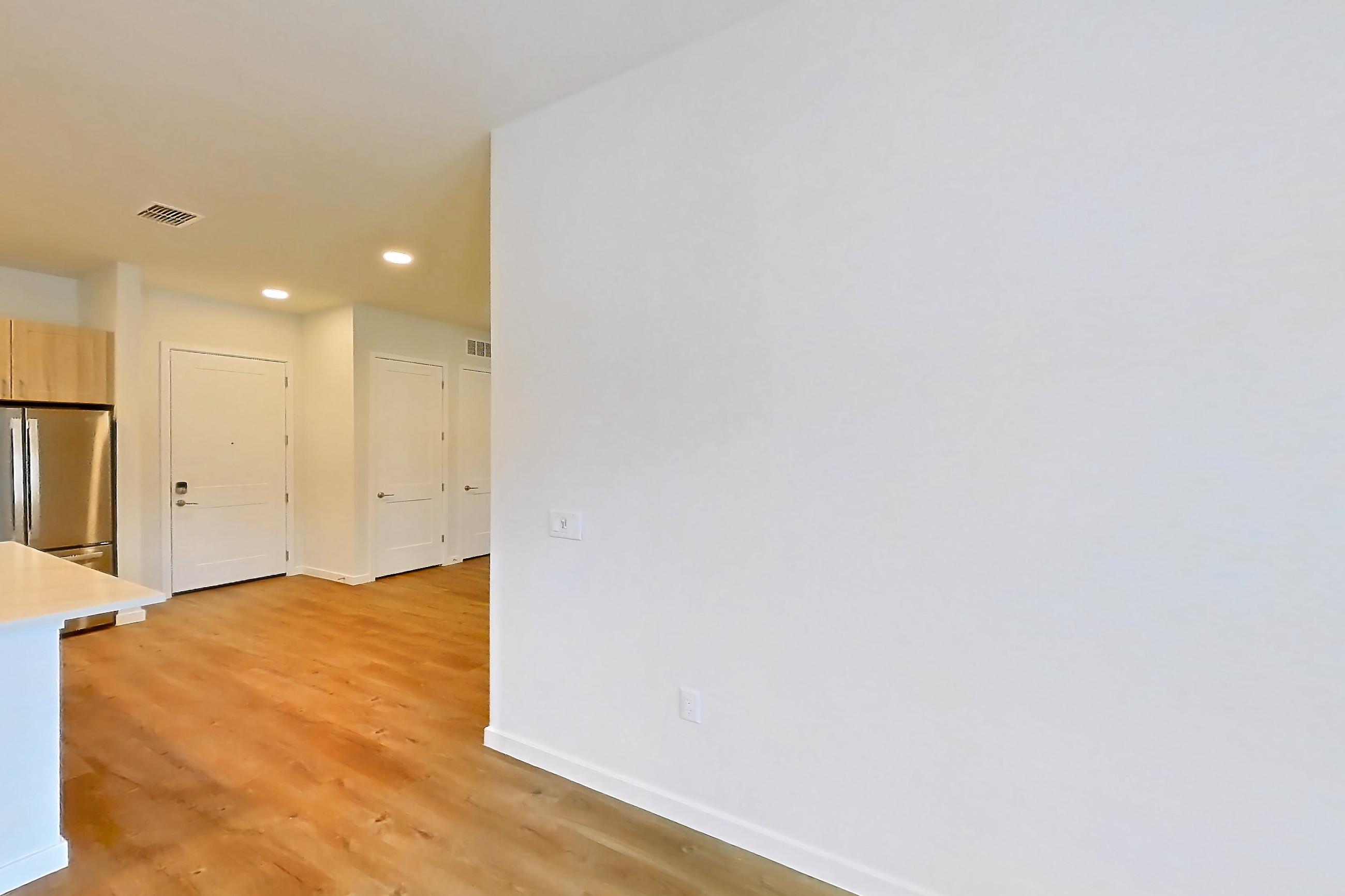 Living space with dishwasher, light countertops, light wood-finish flooring, oven/range, refrigerator, and stainless steel appliances, Apartment 239 at Lantower Bayside