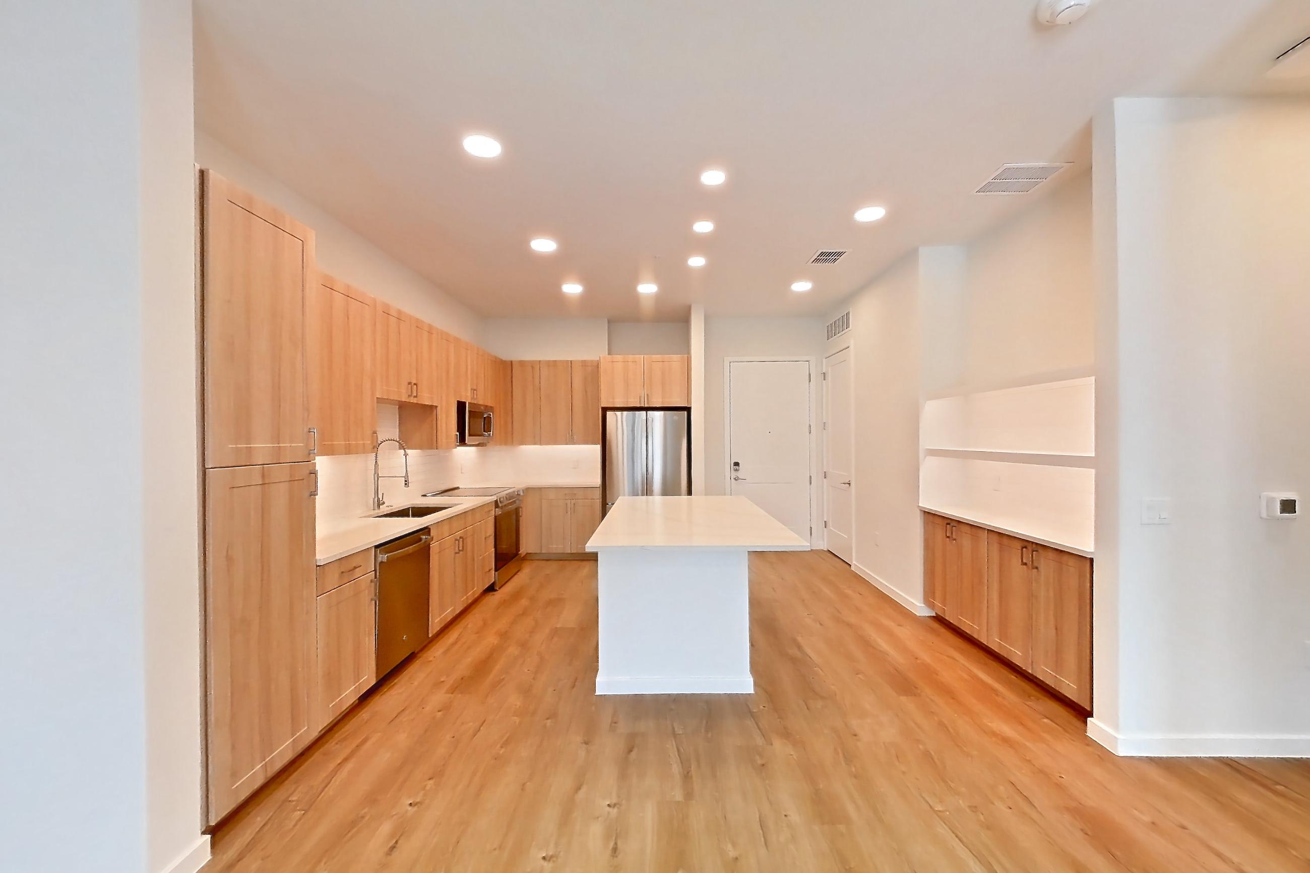 Living space with dishwasher, electric range, light countertops, light wood-finish flooring, oven/range, refrigerator, and stainless steel appliances, Apartment 240 at Lantower Bayside