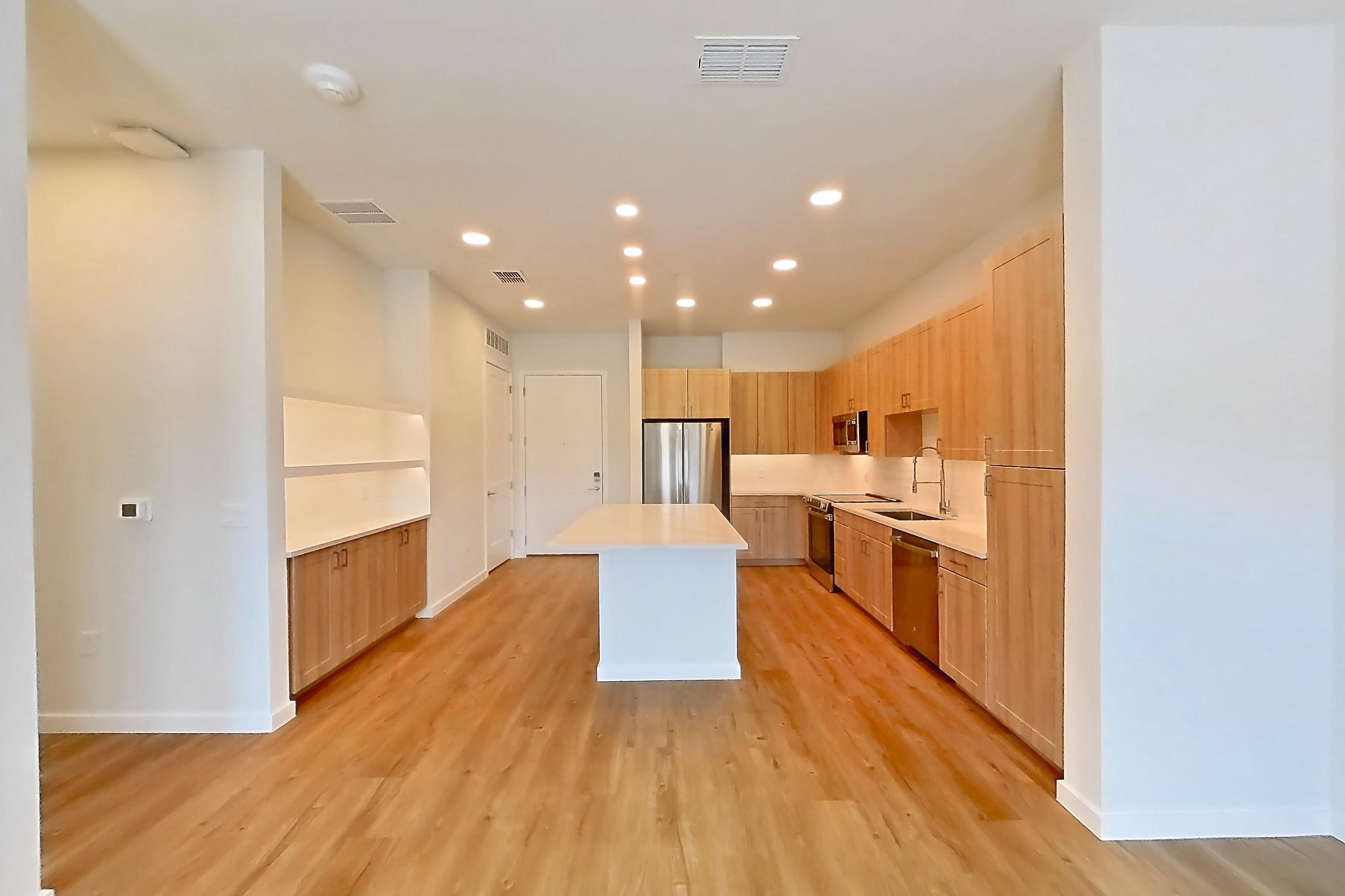 Living space with dishwasher, light countertops, light wood-finish flooring, oven/range, refrigerator, and stainless steel appliances, Apartment 241 at Lantower Bayside