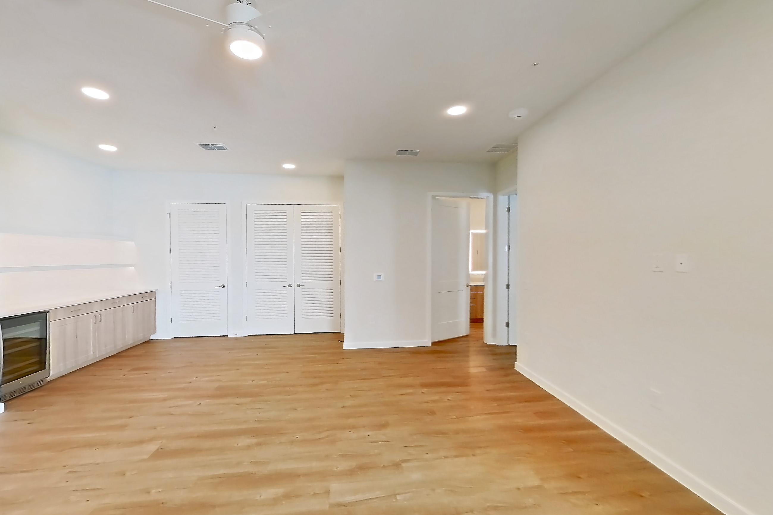 Living space with dishwasher, light countertops, light wood-finish flooring, oven/range, refrigerator, and stainless steel appliances, Apartment 242 at Lantower Bayside