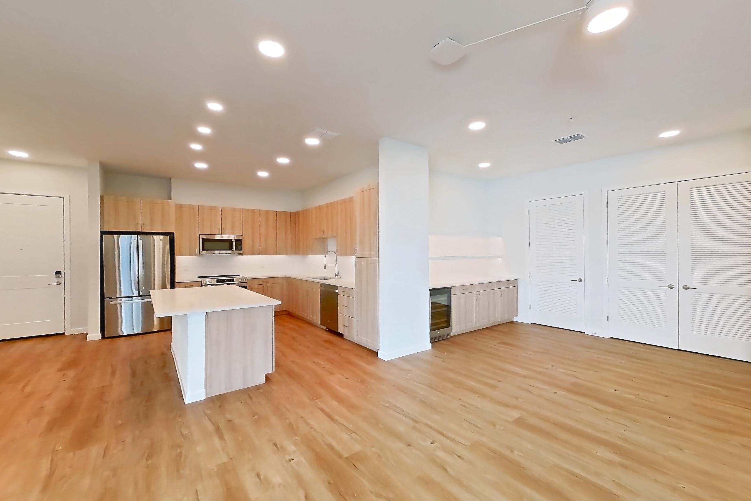 Living space with dishwasher, light countertops, light wood-finish flooring, oven/range, refrigerator, and stainless steel appliances, Apartment 242 at Lantower Bayside