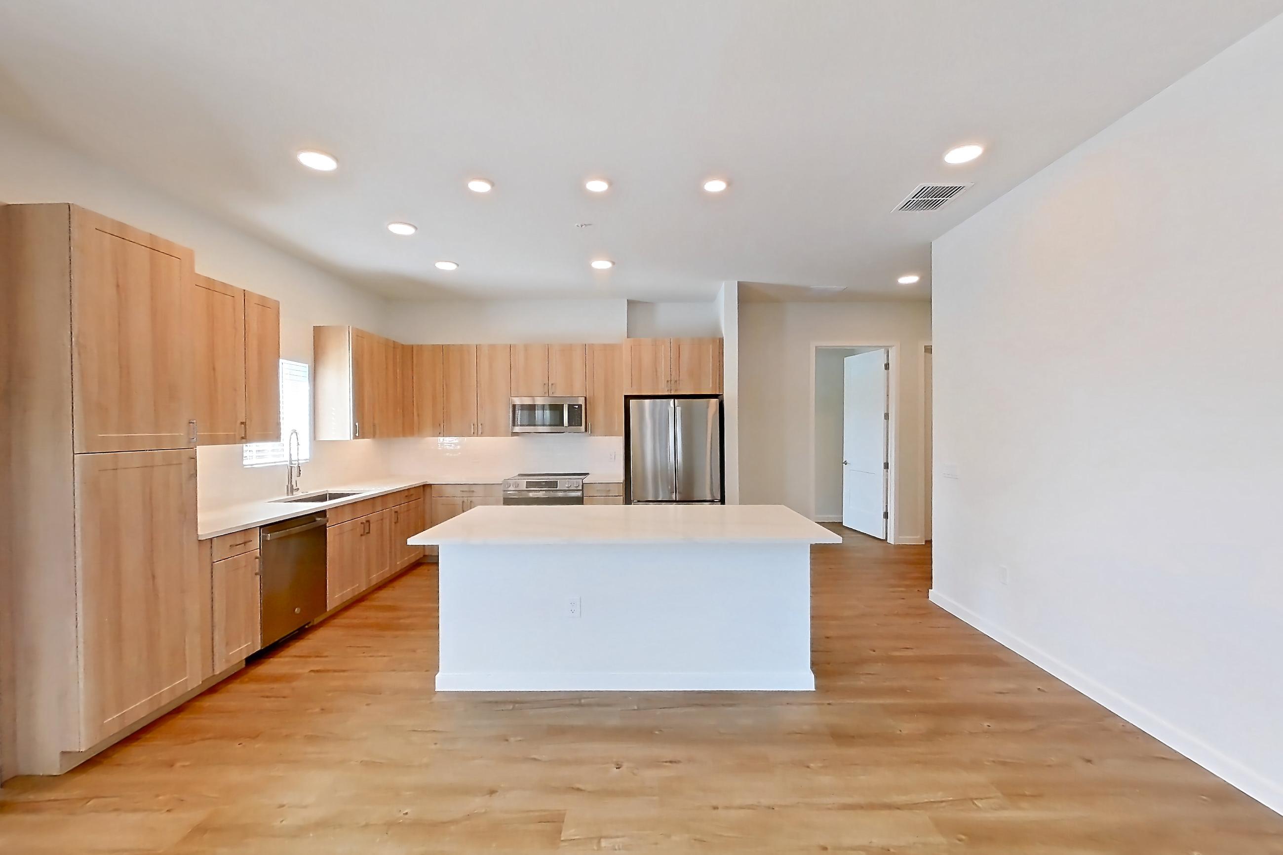 Living space with dishwasher, light countertops, light wood-finish flooring, oven/range, refrigerator, and stainless steel appliances, Apartment 243 at Lantower Bayside