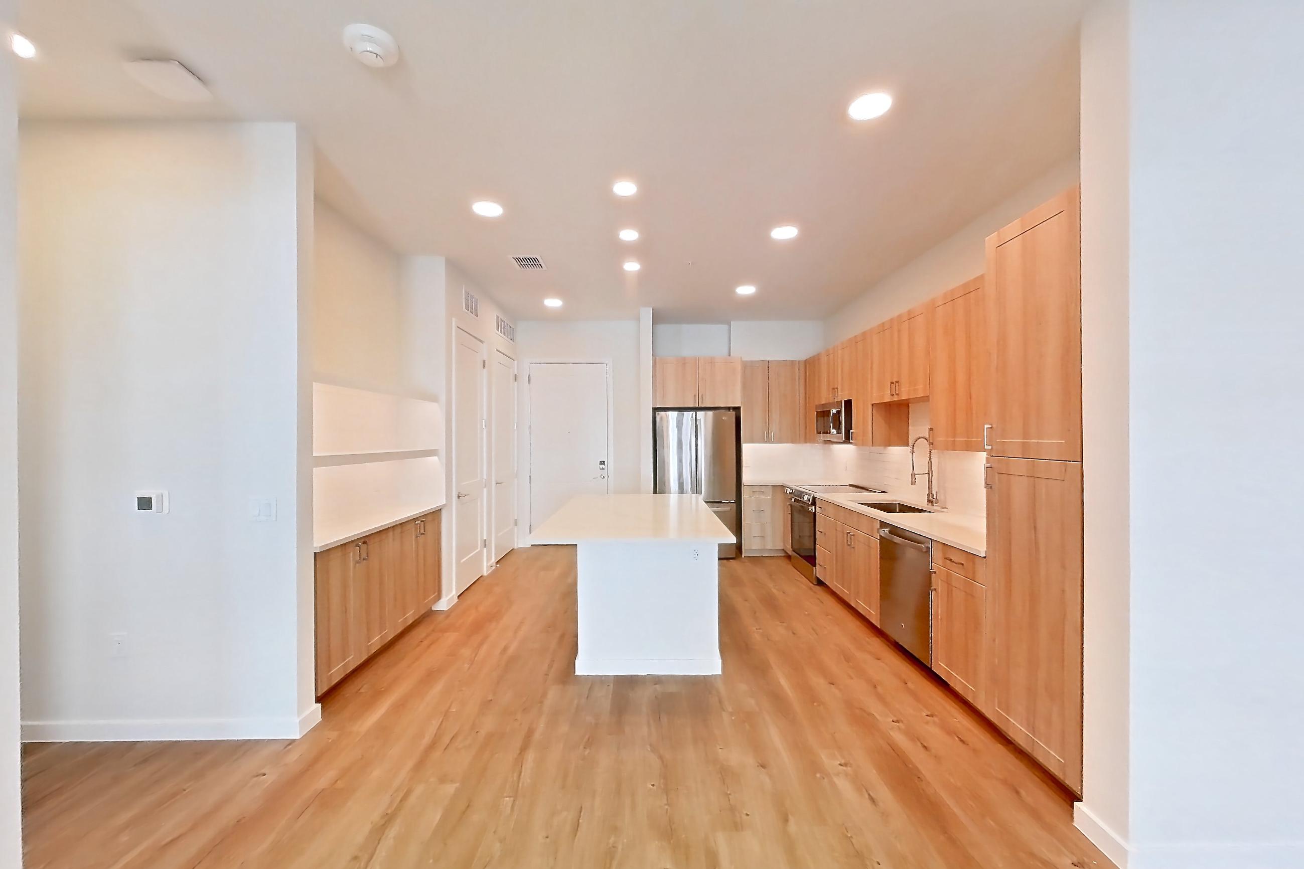 Living space with dishwasher, electric range, light stone countertops, light wood-finish flooring, oven/range, refrigerator, and stainless steel appliances, Apartment 248 at Lantower Bayside