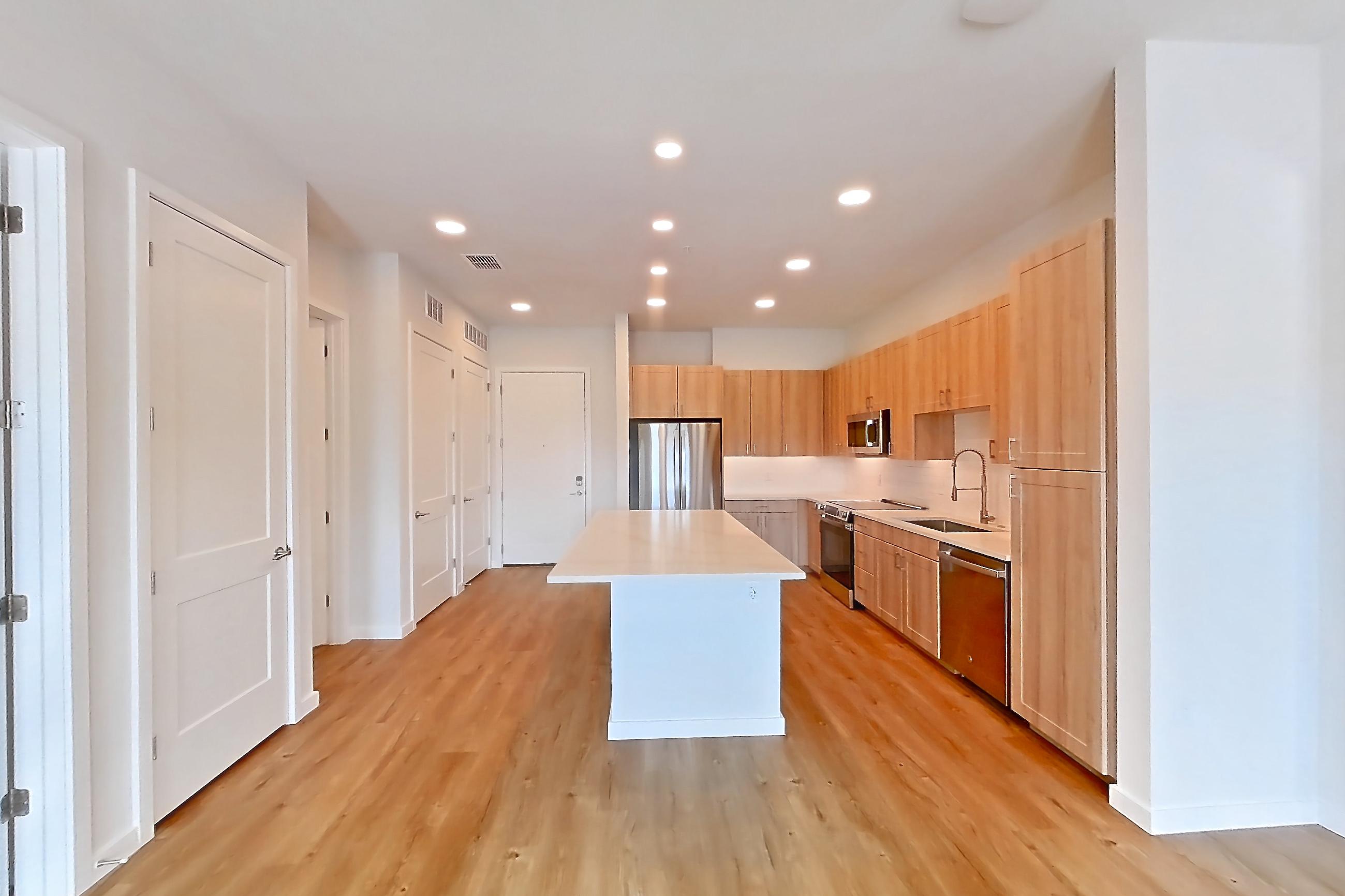 Living space with dishwasher, electric range, light countertops, light wood-finish flooring, oven/range, and stainless steel appliances, Apartment 251 at Lantower Bayside
