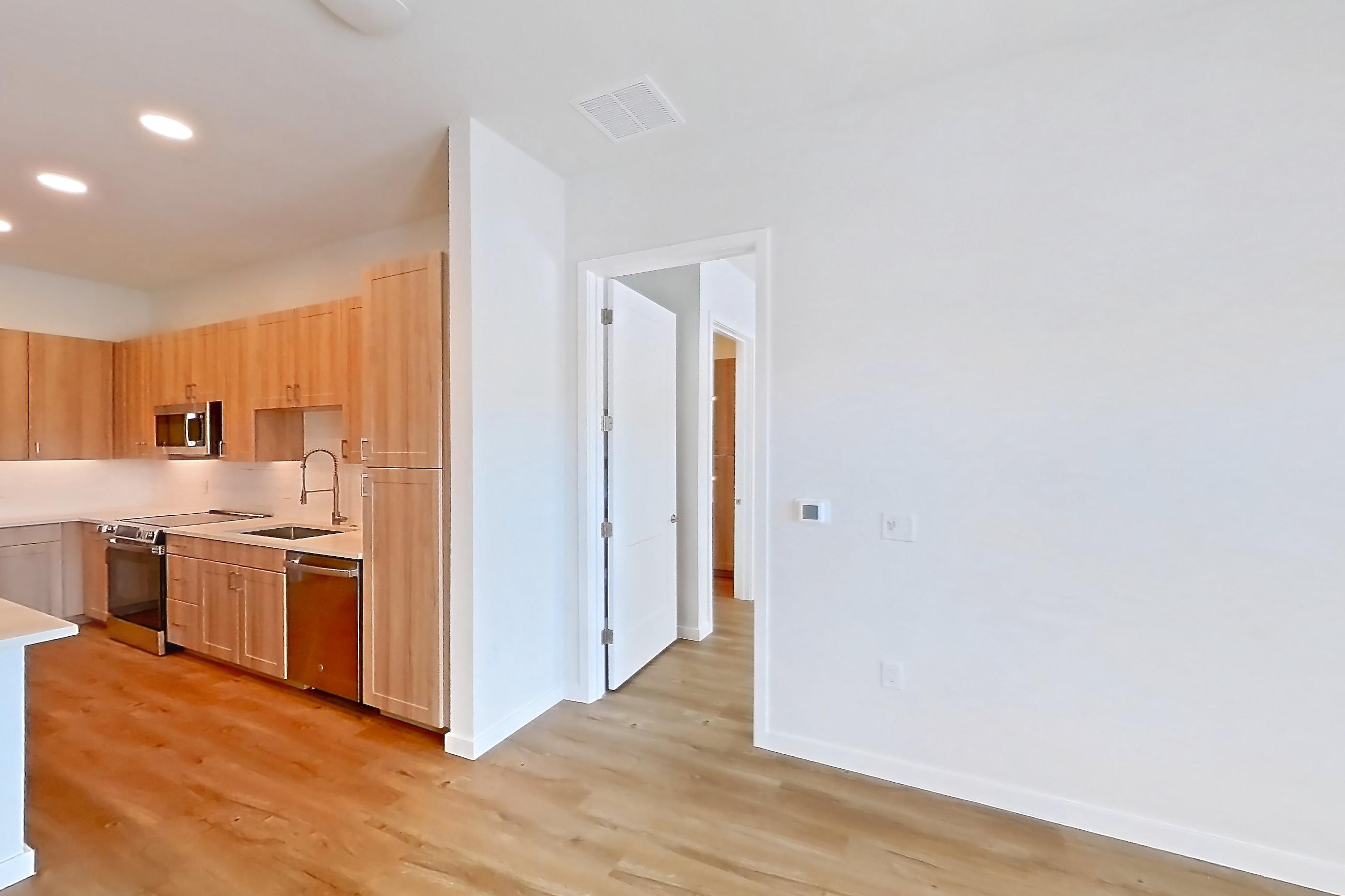 Living space with dishwasher, electric range, light countertops, light wood-finish flooring, oven/range, and stainless steel appliances, Apartment 251 at Lantower Bayside
