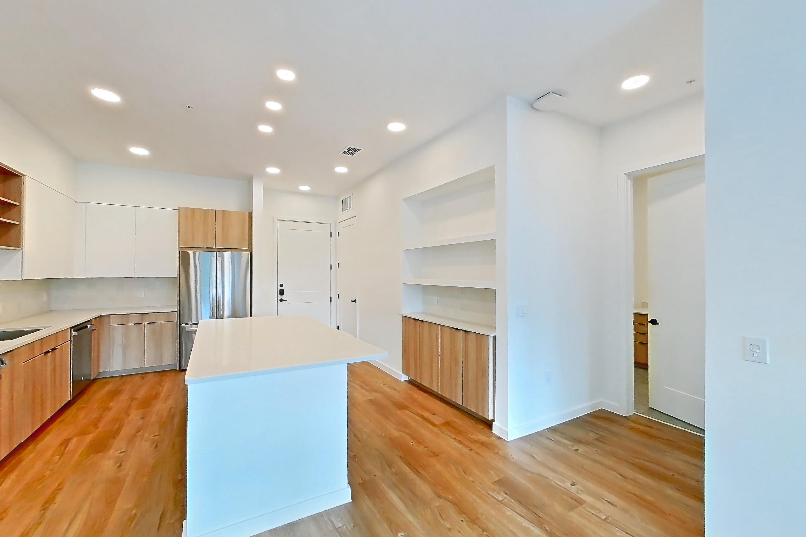 Living room with baseboard heating, electric range, light countertops, light wood-finish flooring, oven/range, refrigerator, and stainless steel appliances, Apartment 240 at Lantower Sunrise