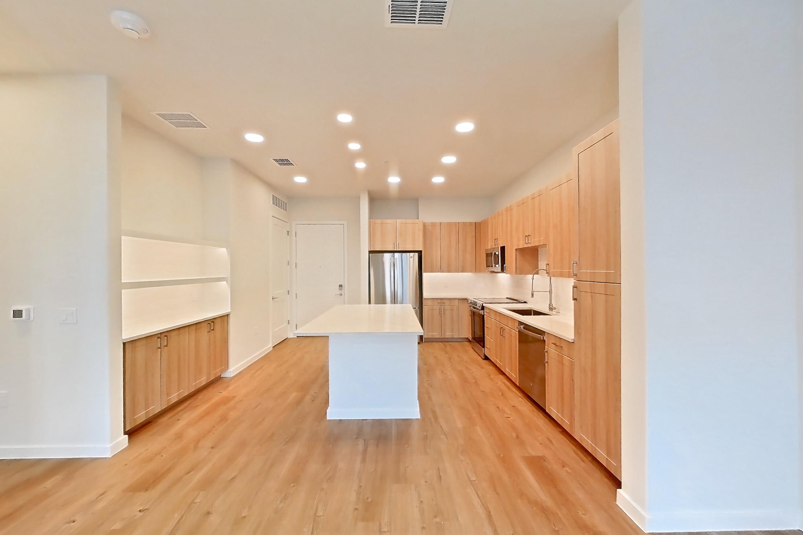 Living space with dishwasher, electric range, light countertops, light wood-finish flooring, oven/range, refrigerator, and stainless steel appliances, Apartment 258 at Lantower Bayside