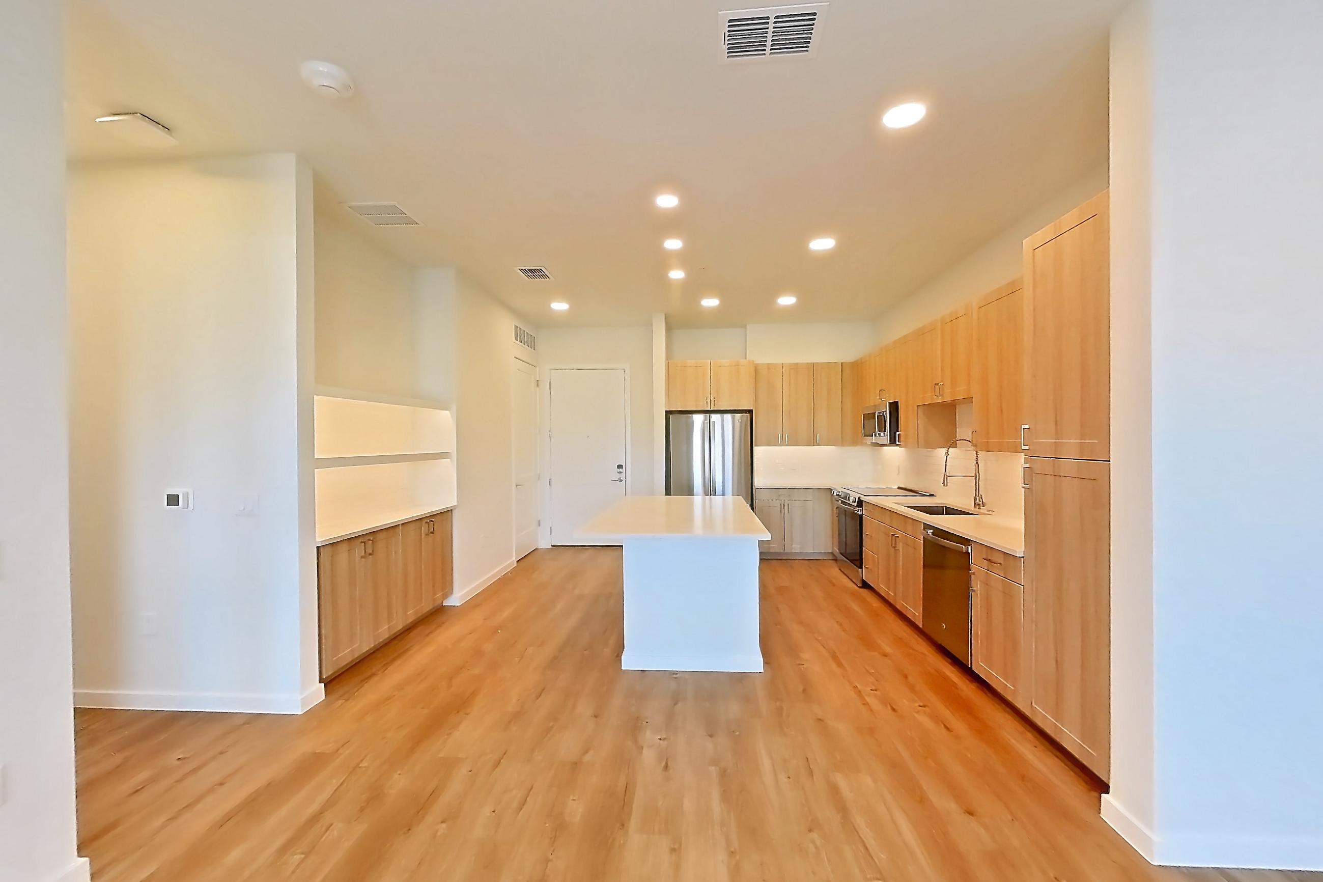 Living space with dishwasher, electric range, light countertops, light wood-finish flooring, oven/range, refrigerator, and stainless steel appliances, Apartment 259 at Lantower Bayside