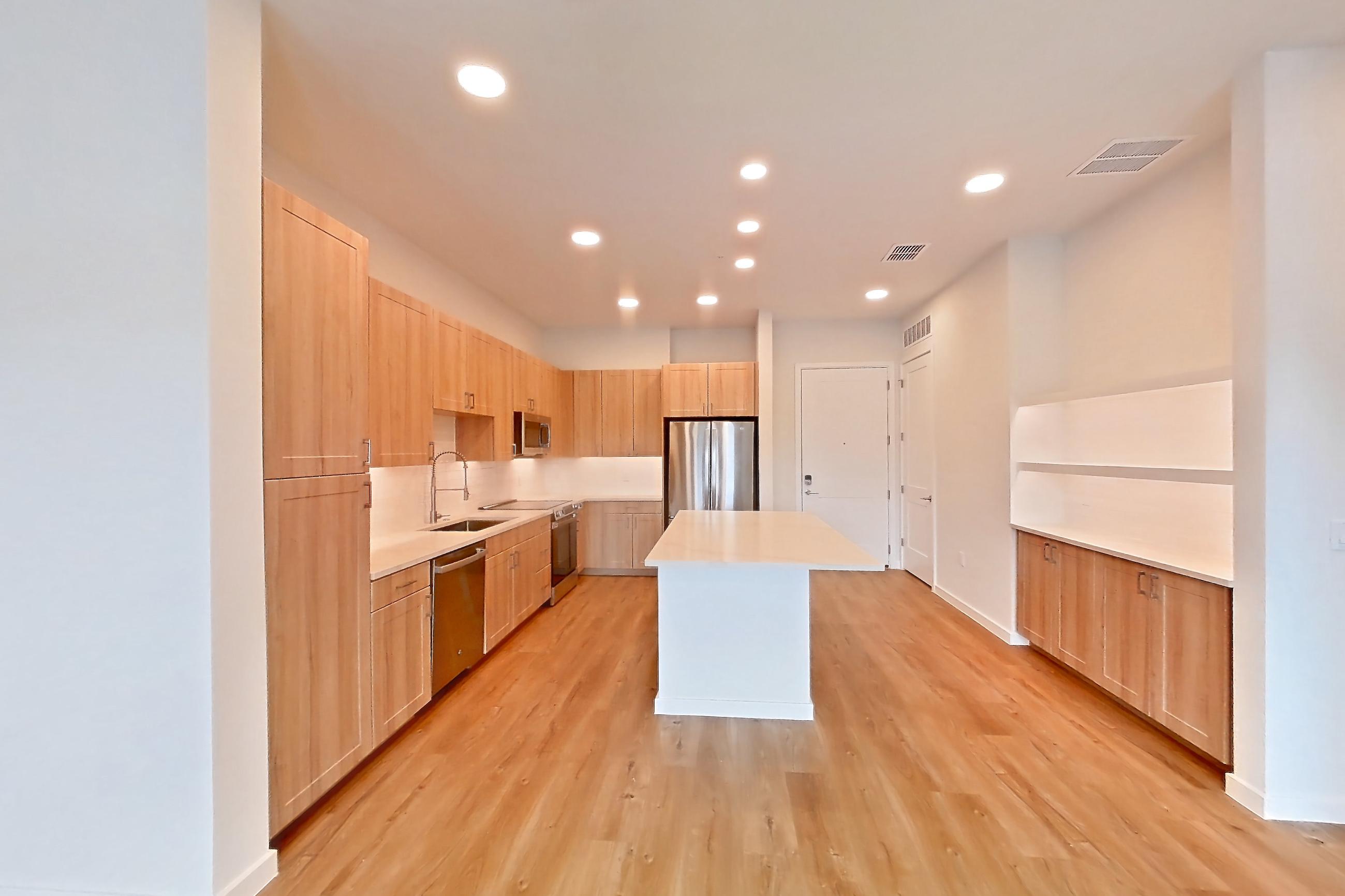 Living space with dishwasher, electric range, light countertops, light wood-finish flooring, oven/range, refrigerator, and stainless steel appliances, Apartment 331 at Lantower Bayside