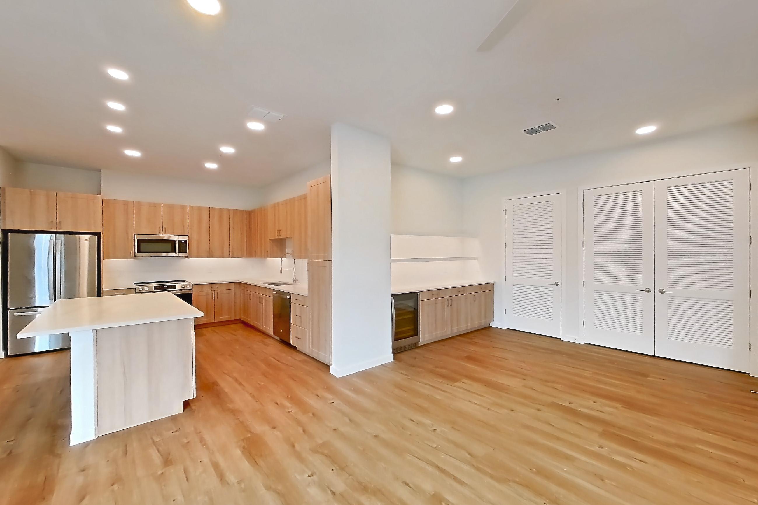 Living space with dishwasher, electric range, light countertops, light wood-finish flooring, oven/range, refrigerator, and stainless steel appliances, Apartment 332 at Lantower Bayside