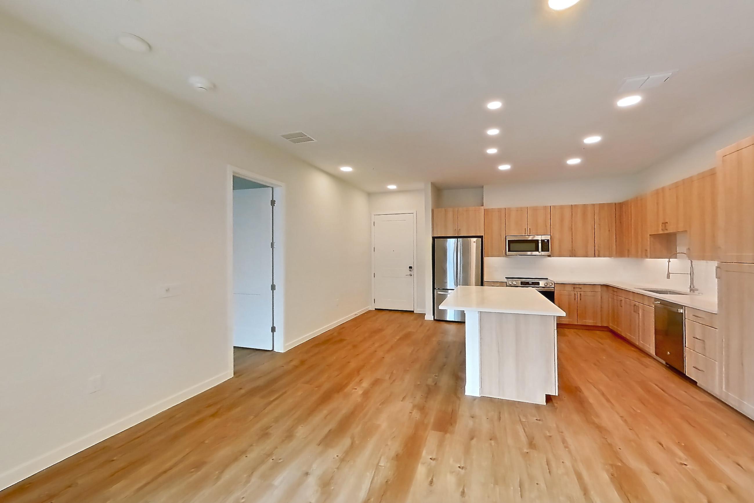 Living space with dishwasher, electric range, light countertops, light wood-finish flooring, oven/range, refrigerator, and stainless steel appliances, Apartment 332 at Lantower Bayside