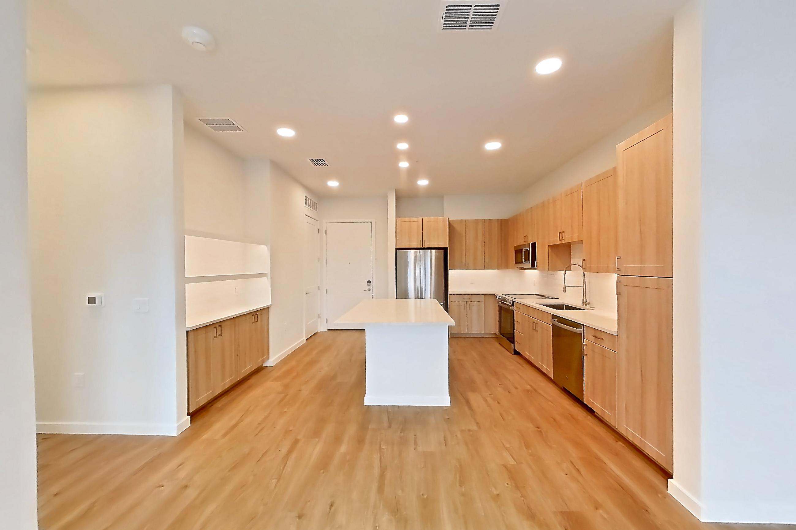 Living space with dishwasher, electric range, light countertops, light wood-finish flooring, oven/range, refrigerator, and stainless steel appliances, Apartment 333 at Lantower Bayside