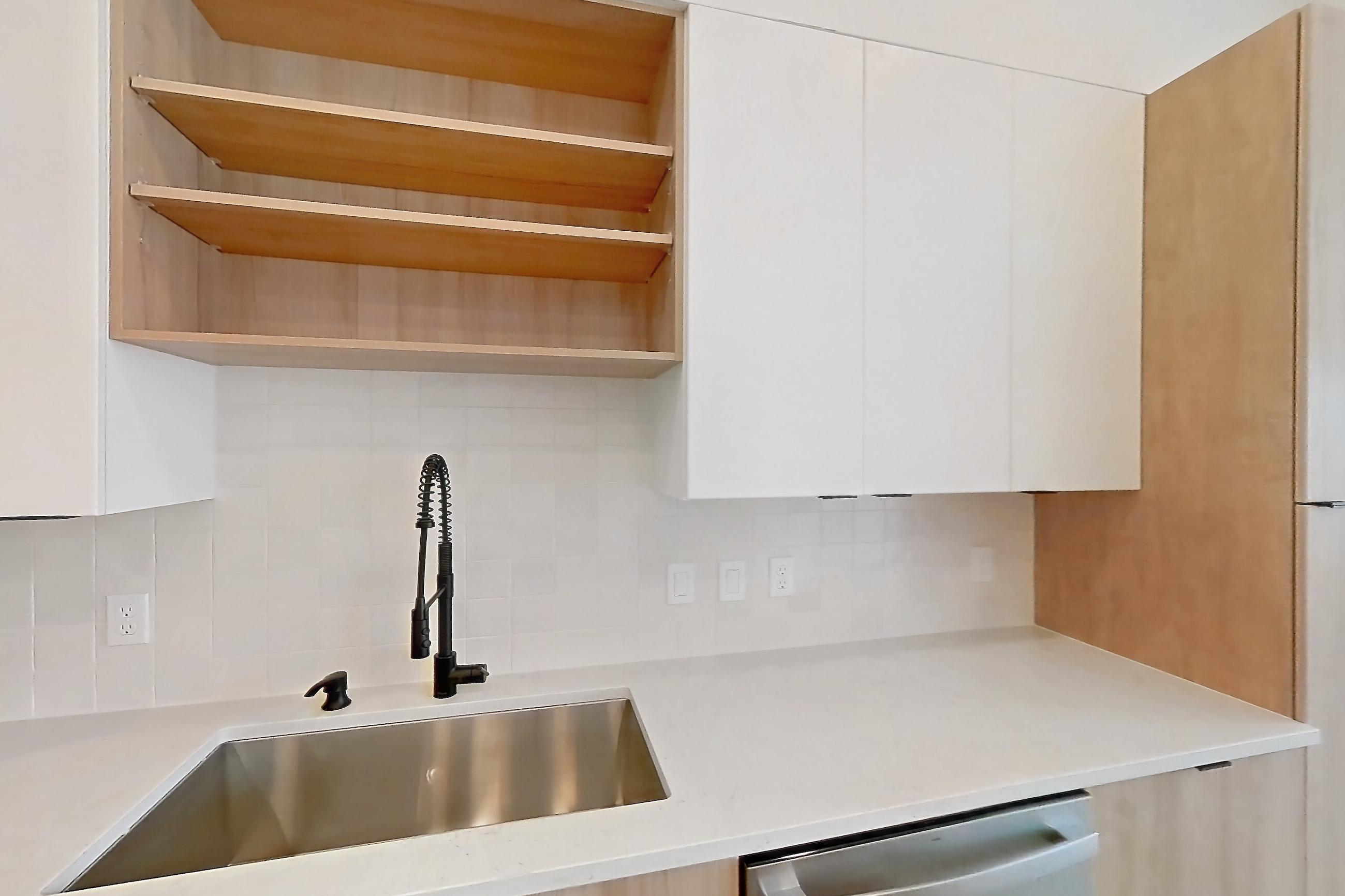 Kitchen with dishwasher, light stone countertops, light wood-finish flooring, refrigerator, and stainless steel appliances, Apartment 146 at Lantower Sunrise