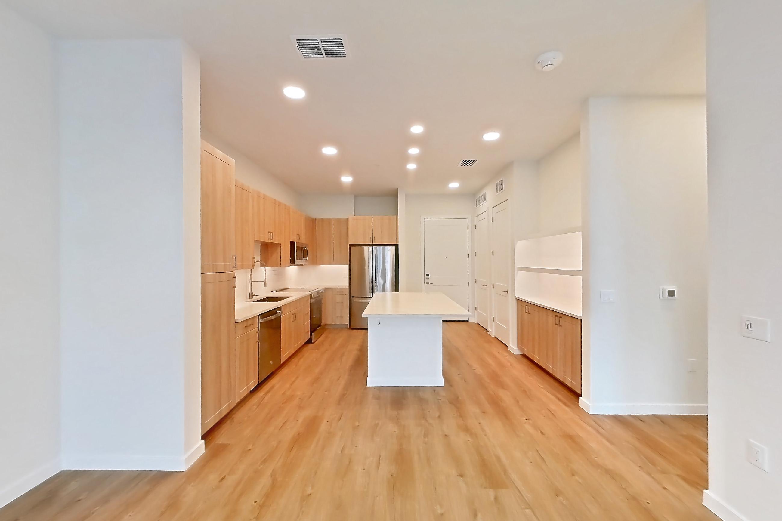 Living space with dishwasher, light countertops, light wood-finish flooring, oven/range, refrigerator, and stainless steel appliances, Apartment 338 at Lantower Bayside