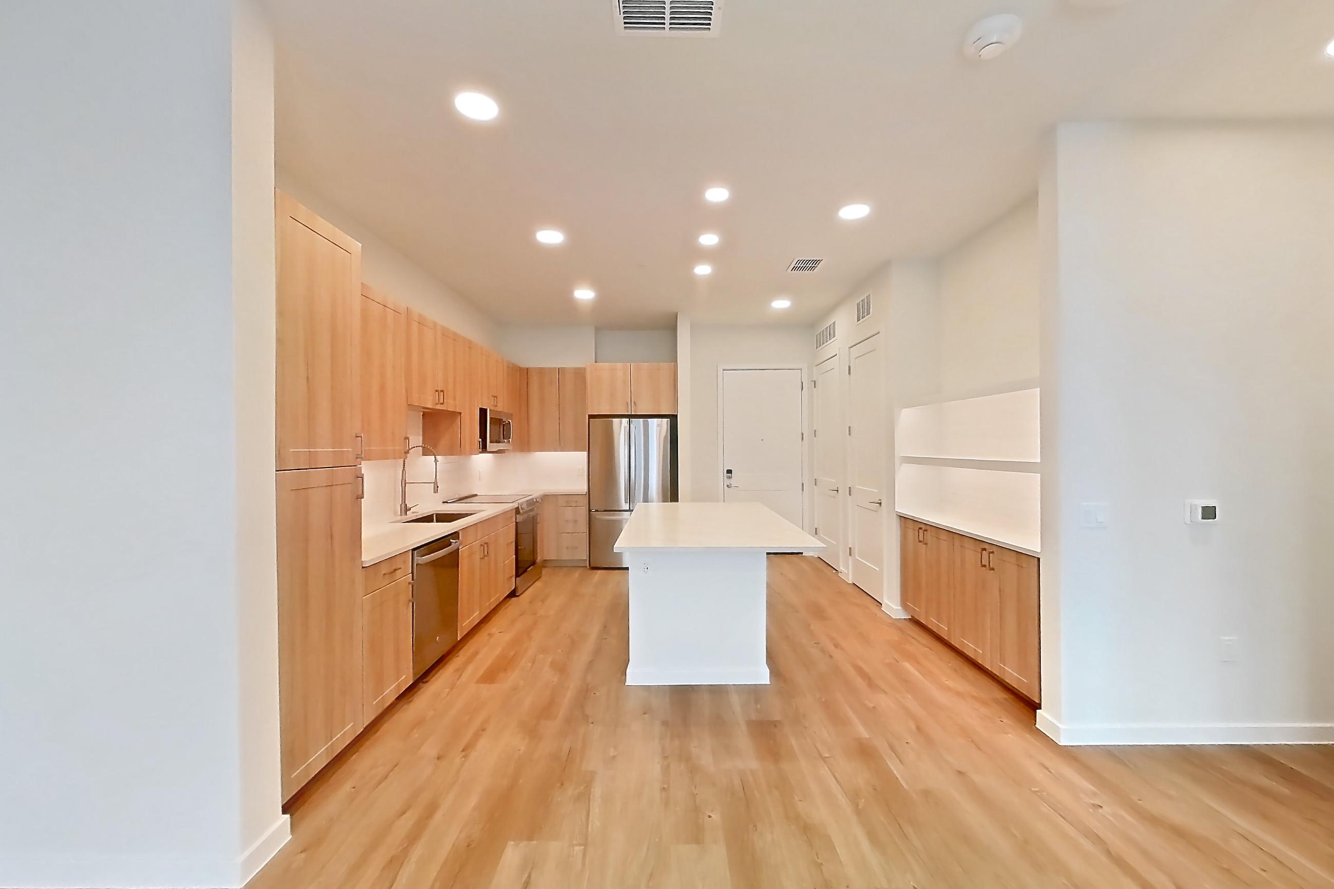 Living space with dishwasher, electric range, light countertops, light wood-finish flooring, oven/range, refrigerator, and stainless steel appliances, Apartment 339 at Lantower Bayside