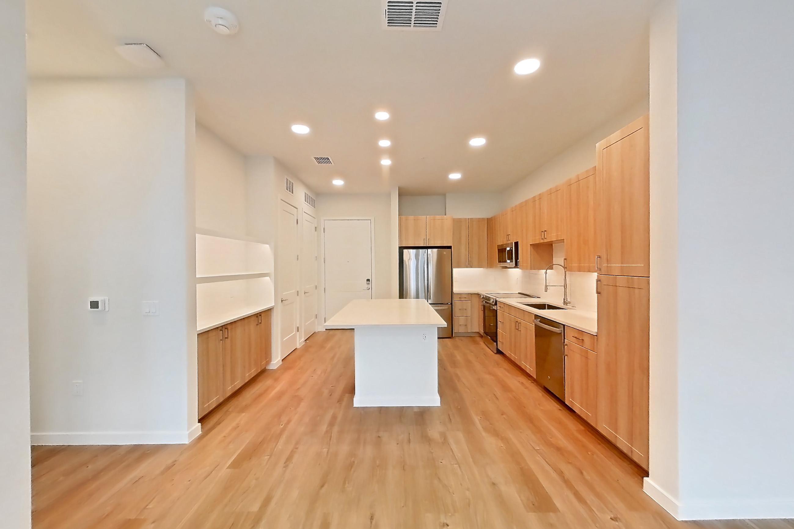 Living space with dishwasher, electric range, light countertops, light wood-finish flooring, oven/range, refrigerator, and stainless steel appliances, Apartment 340 at Lantower Bayside