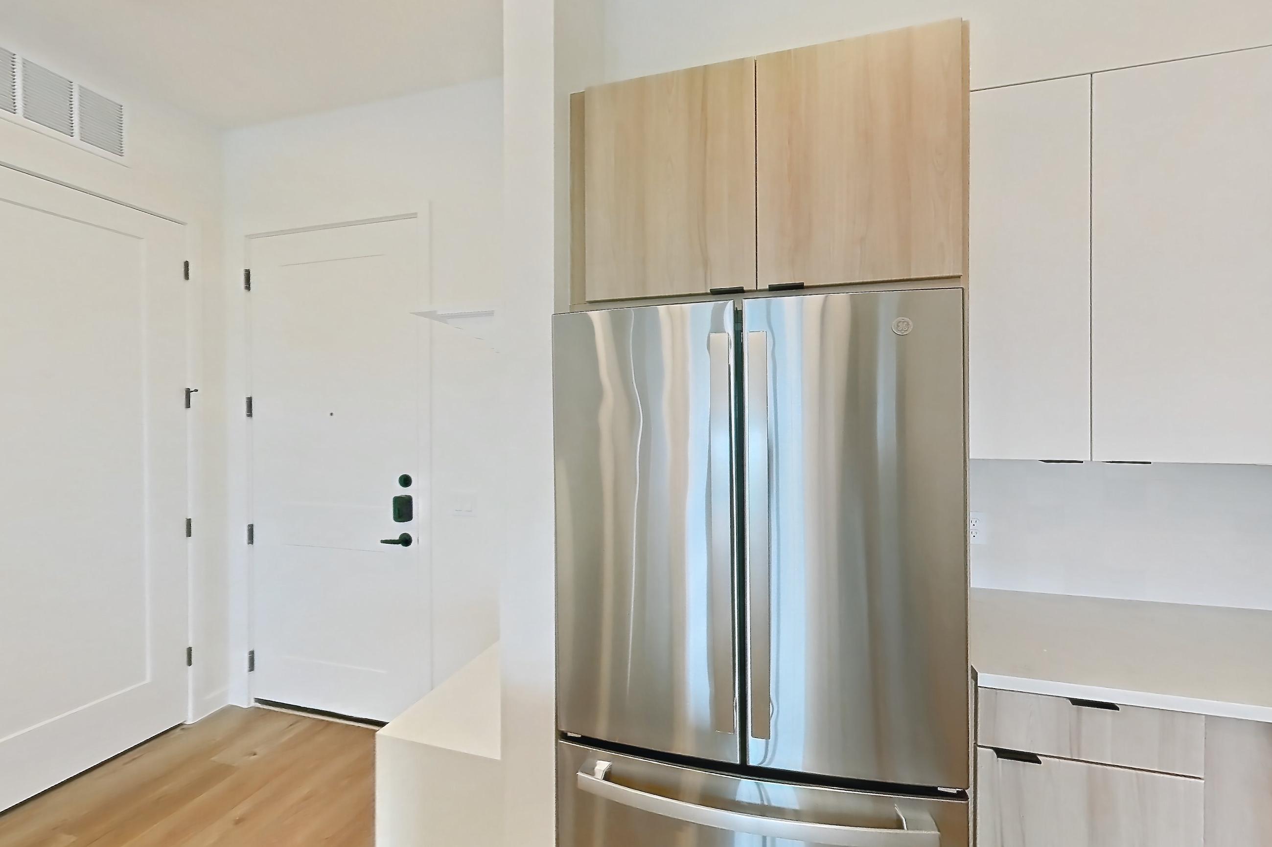 Kitchen with dishwasher, electric range, light stone countertops, light wood-finish flooring, microwave, oven/range, refrigerator, and stainless steel appliances, Apartment 330 at Lantower Sunrise