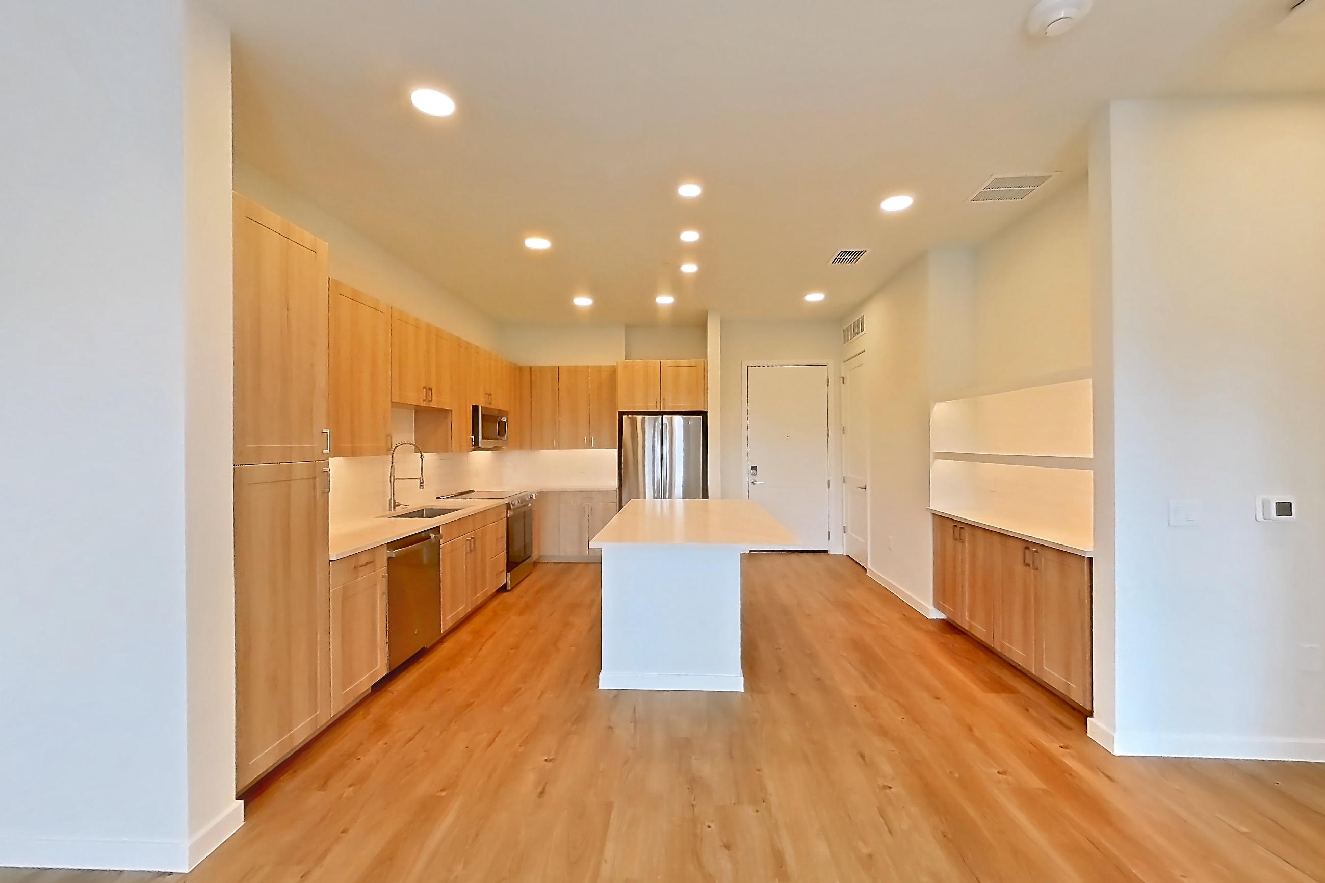 Living space with dishwasher, light countertops, light wood-finish flooring, oven/range, refrigerator, and stainless steel appliances, Apartment 431 at Lantower Bayside