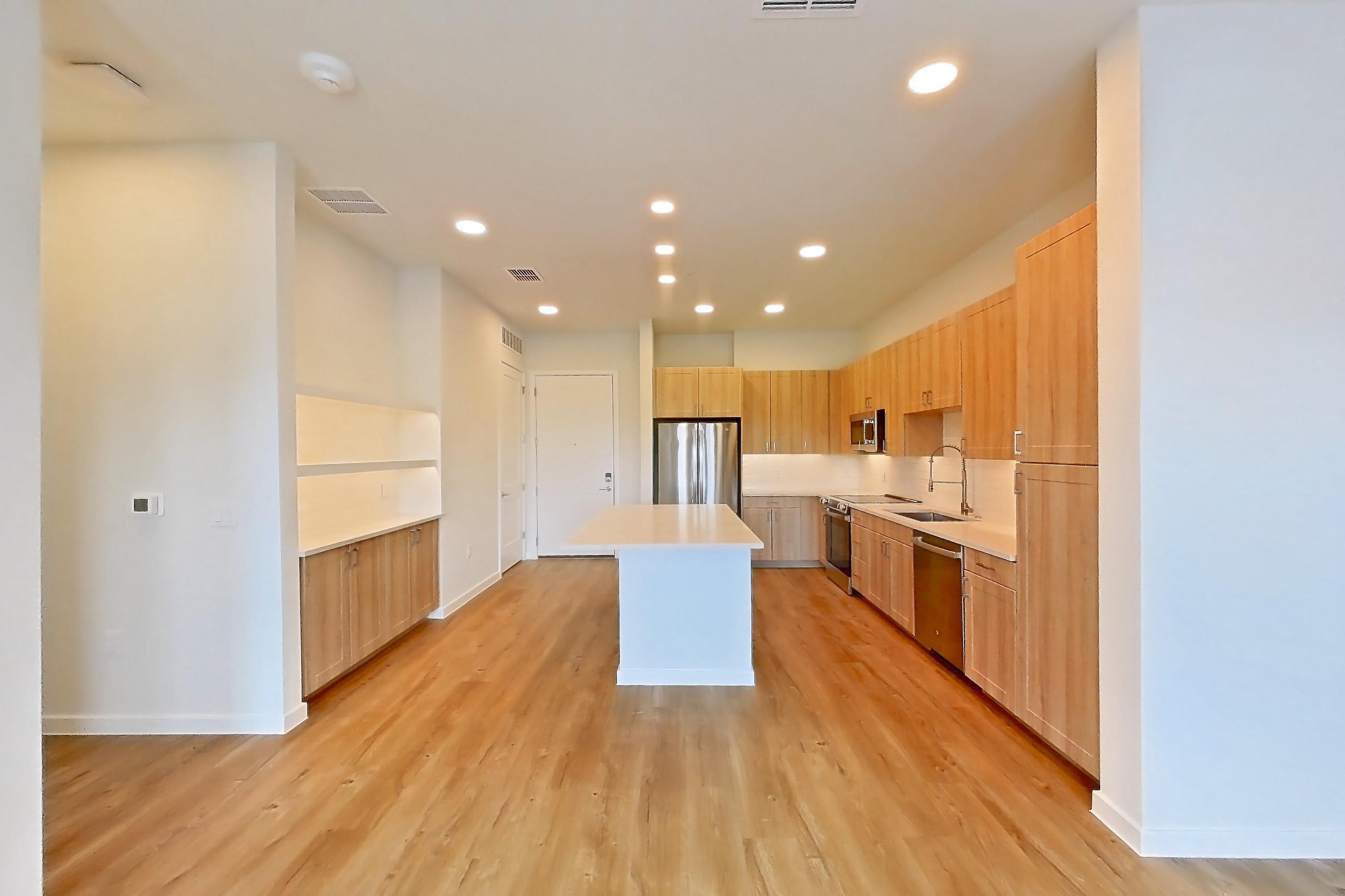 Living space with dishwasher, electric range, light countertops, light wood-finish flooring, oven/range, refrigerator, and stainless steel appliances, Apartment 433 at Lantower Bayside