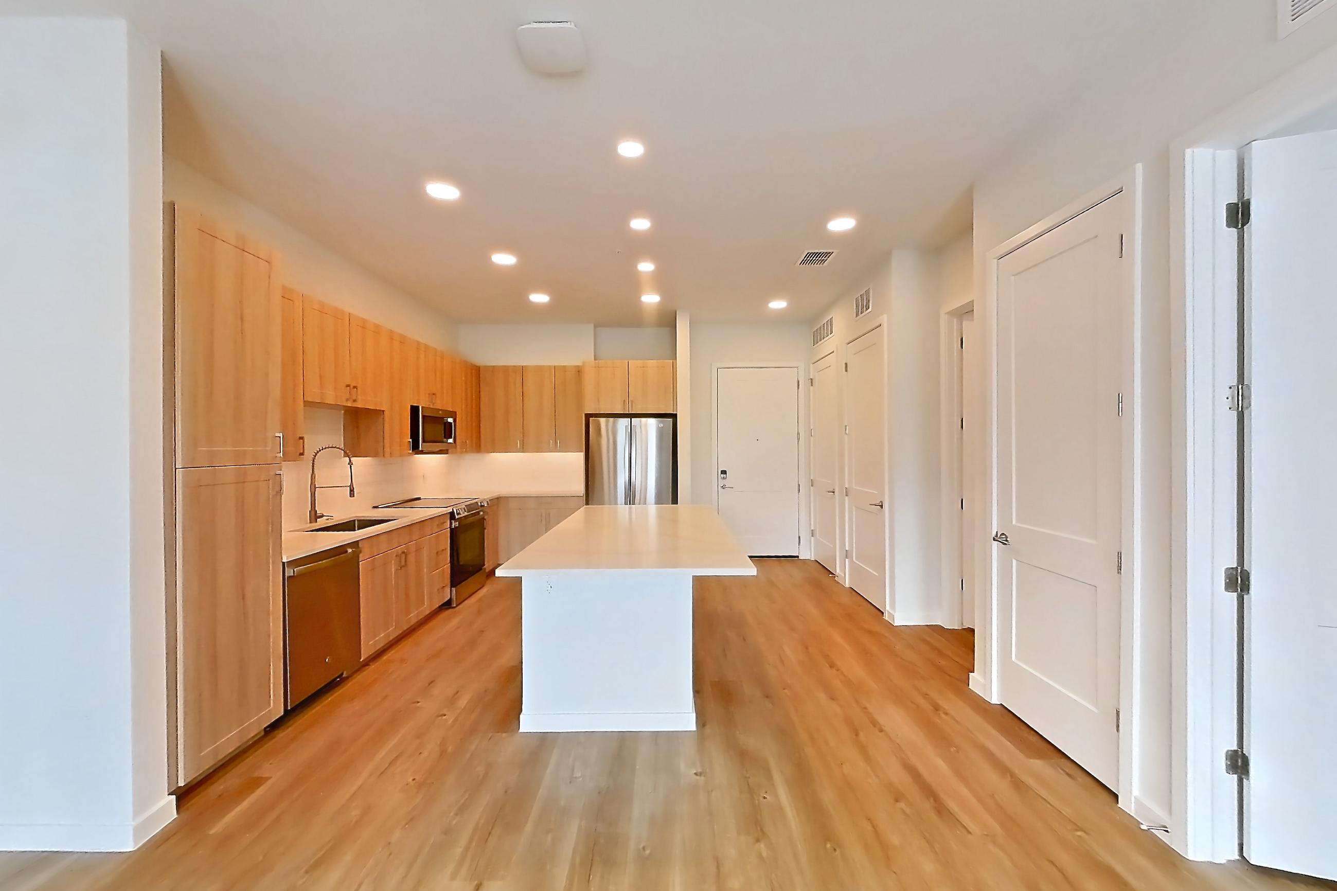 Living space with dishwasher, electric range, light countertops, light wood-finish flooring, oven/range, and stainless steel appliances, Apartment 436 at Lantower Bayside