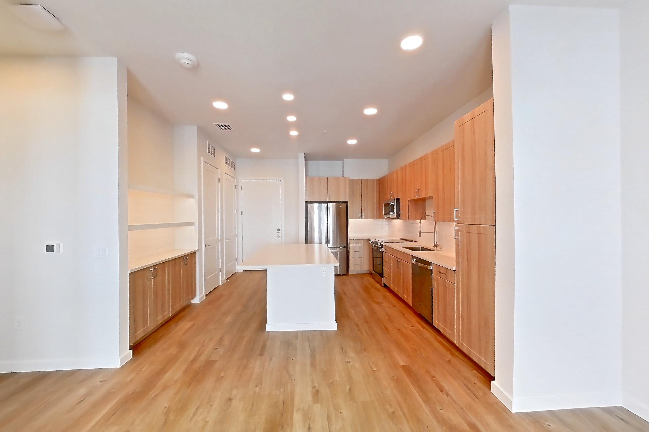 Living space with dishwasher, electric range, light countertops, light wood-finish flooring, oven/range, refrigerator, and stainless steel appliances, Apartment 437 at Lantower Bayside