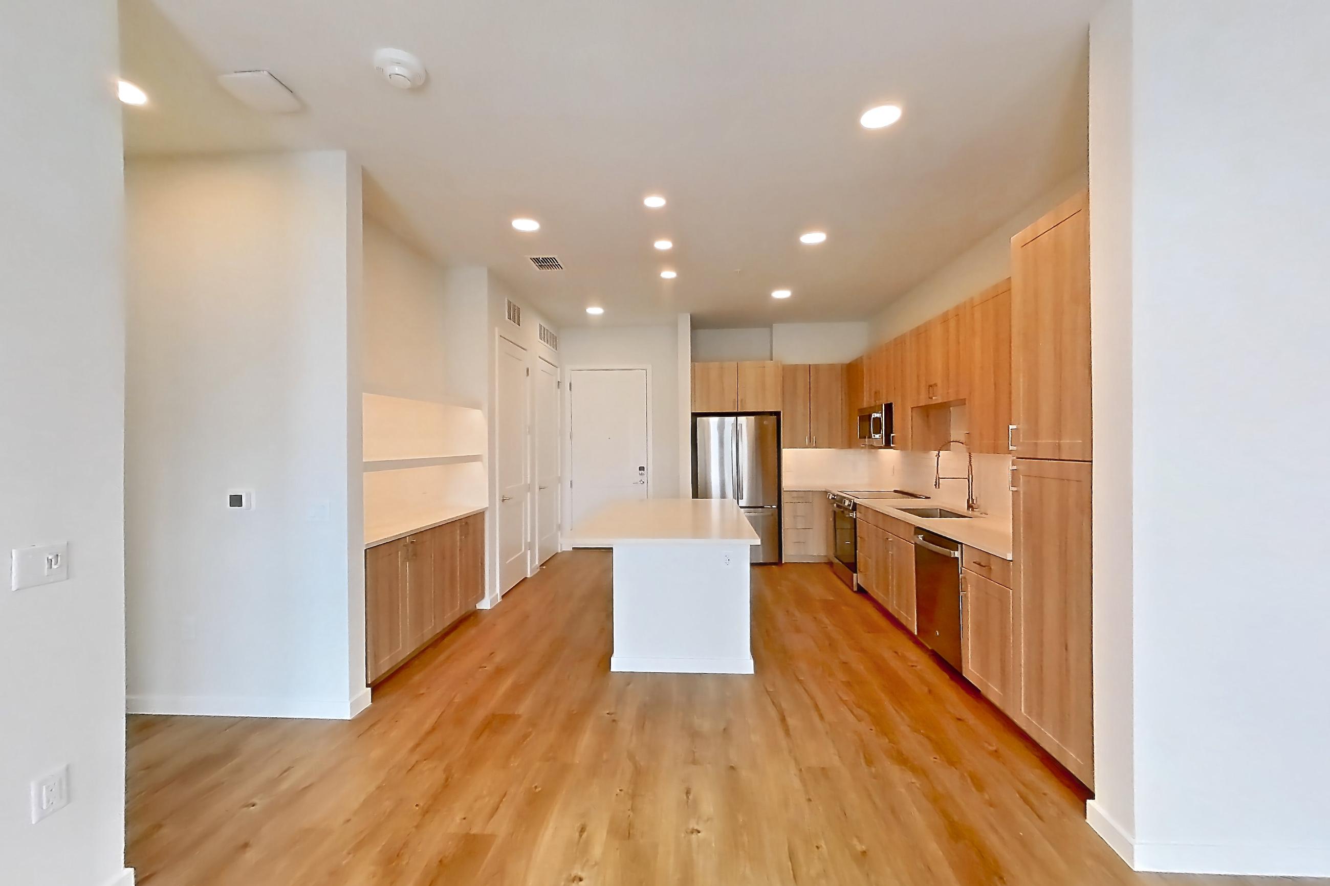 Living space with dishwasher, light countertops, light wood-finish flooring, oven/range, refrigerator, and stainless steel appliances, Apartment 440 at Lantower Bayside