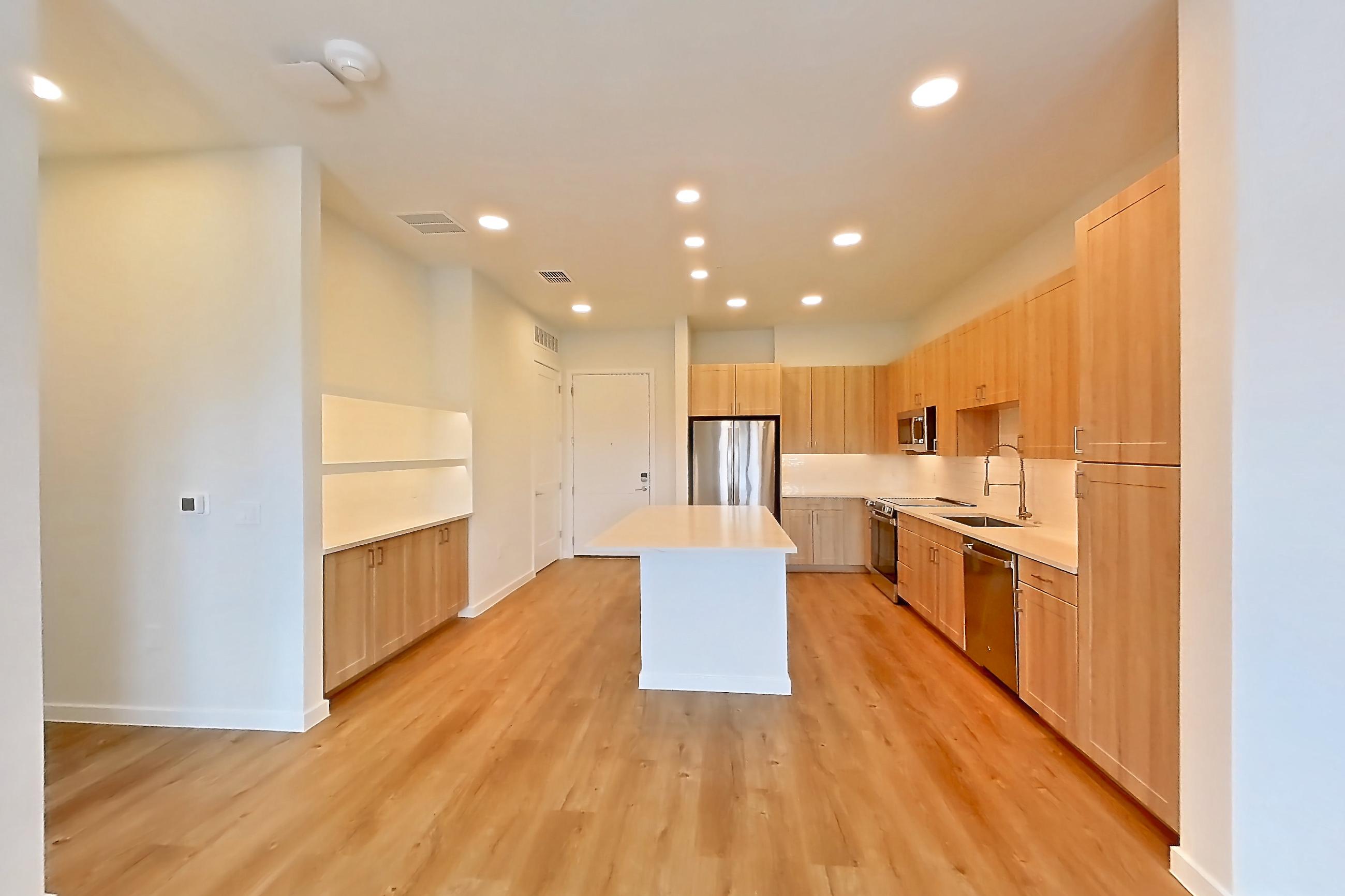 Living space with dishwasher, electric range, light countertops, light wood-finish flooring, oven/range, refrigerator, and stainless steel appliances, Apartment 445 at Lantower Bayside