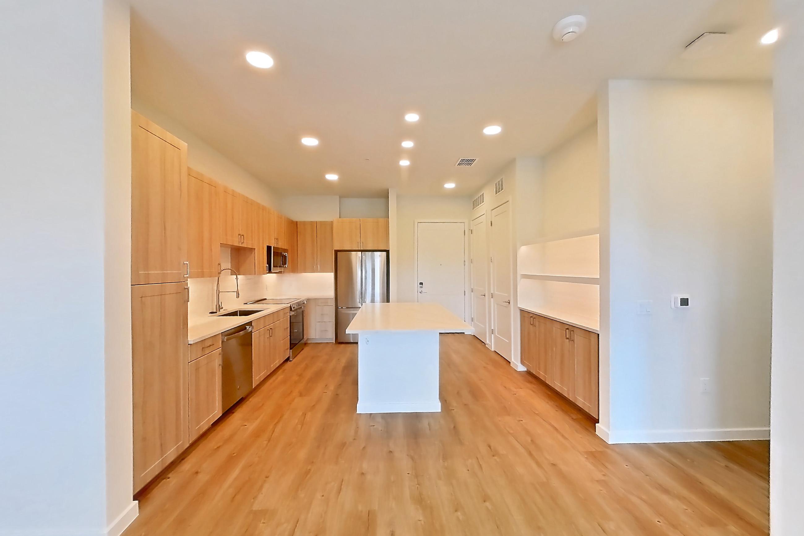 Living space with dishwasher, light countertops, light wood-finish flooring, oven/range, refrigerator, and stainless steel appliances, Apartment 447 at Lantower Bayside