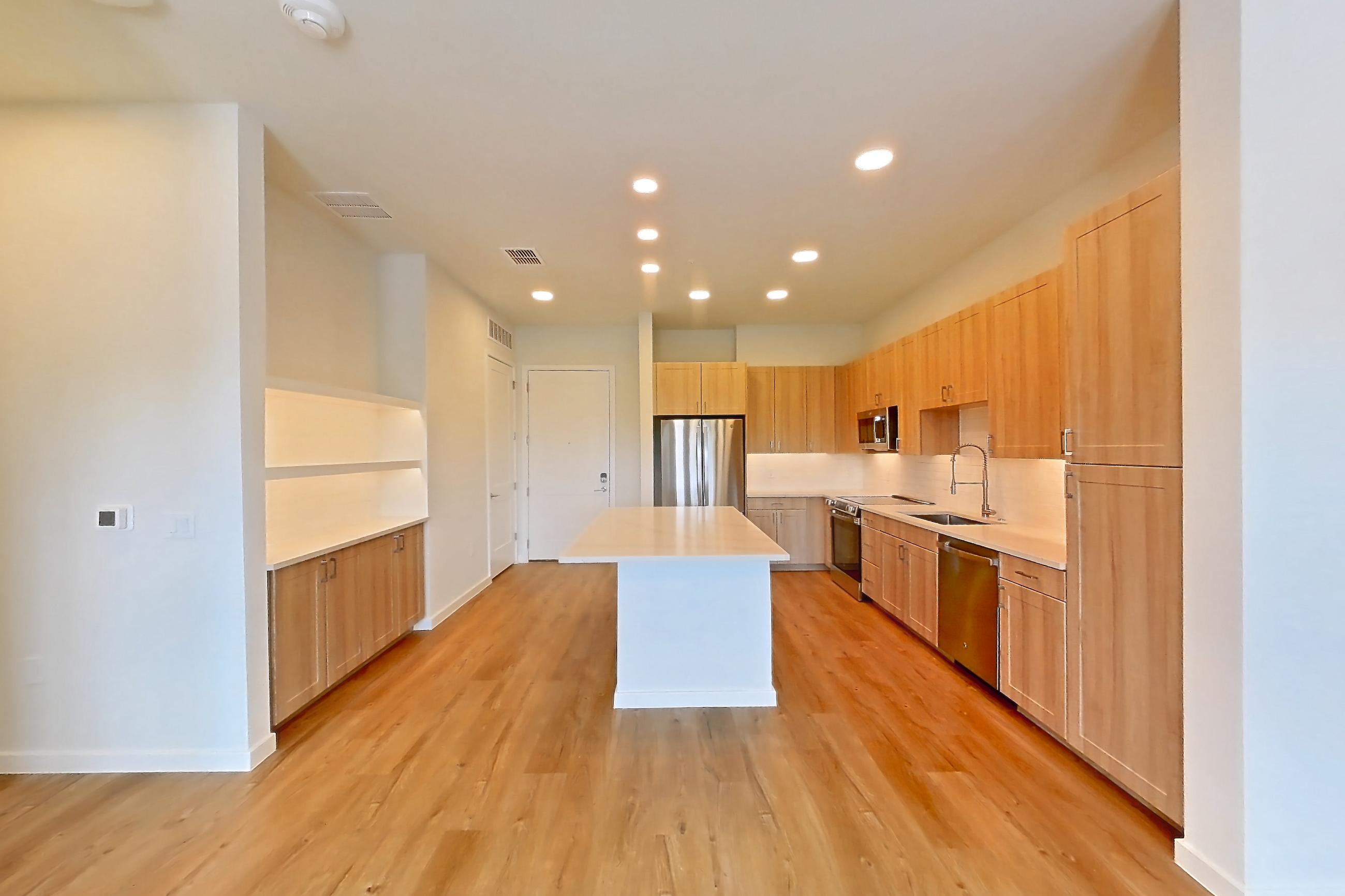 Living space with dishwasher, electric range, light countertops, light wood-finish flooring, oven/range, refrigerator, and stainless steel appliances, Apartment 452 at Lantower Bayside