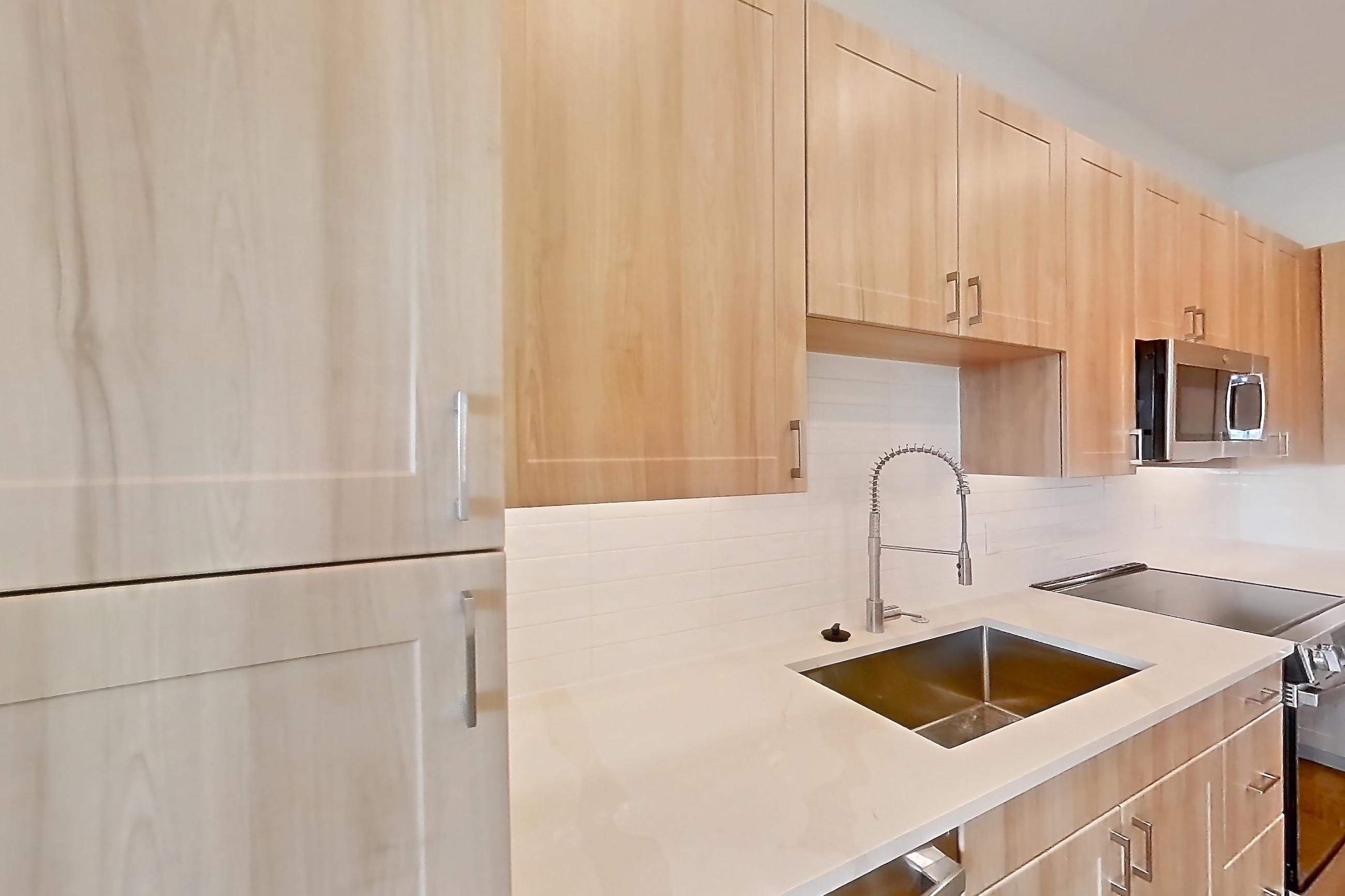 Kitchen with dishwasher, electric range, light countertops, light stone countertops, light wood-finish flooring, oven/range, refrigerator, and stainless steel appliances, Apartment 454 at Lantower Bayside