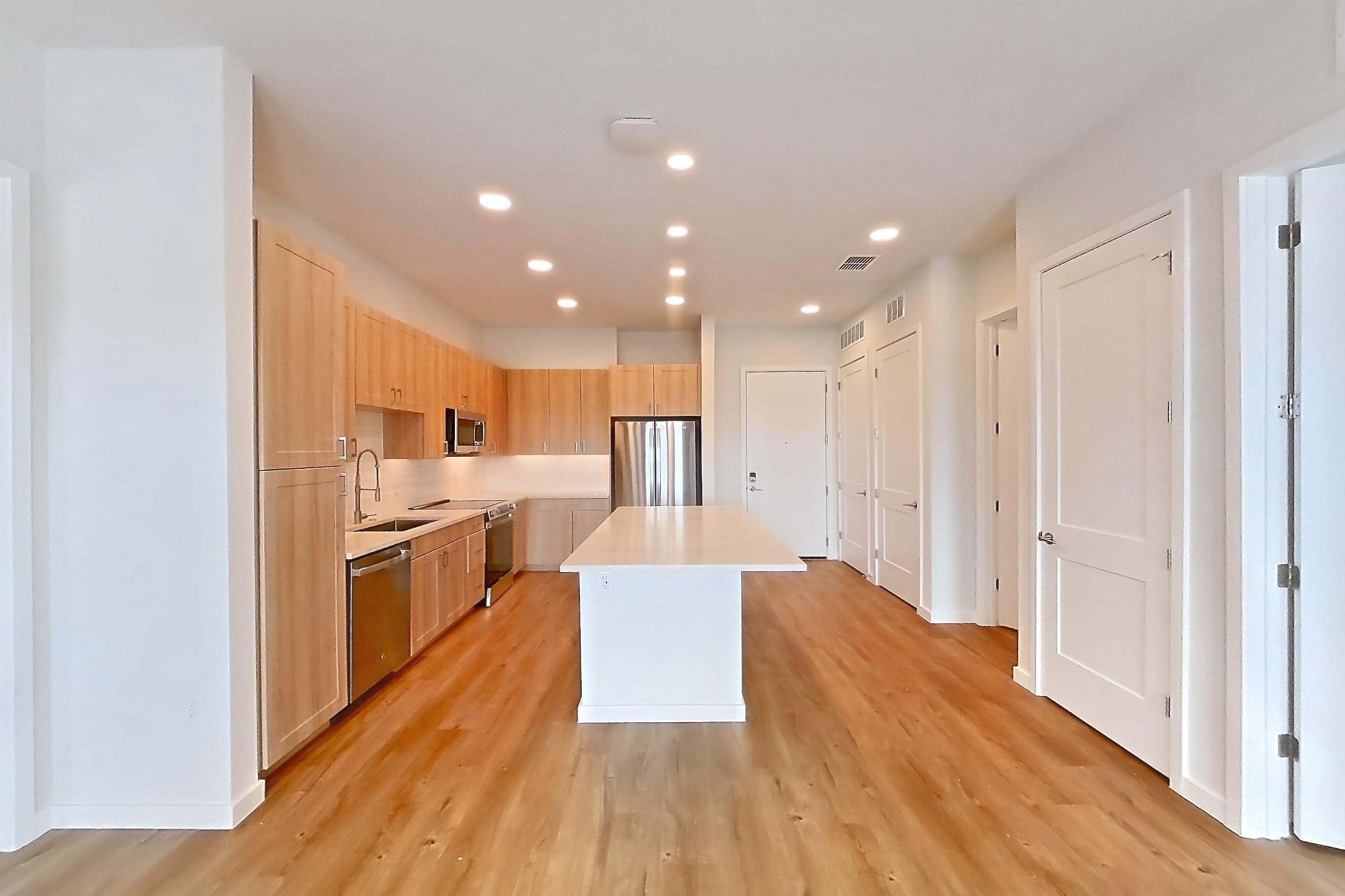 Living space with dishwasher, electric range, light countertops, light wood-finish flooring, oven/range, and stainless steel appliances, Apartment 455 at Lantower Bayside