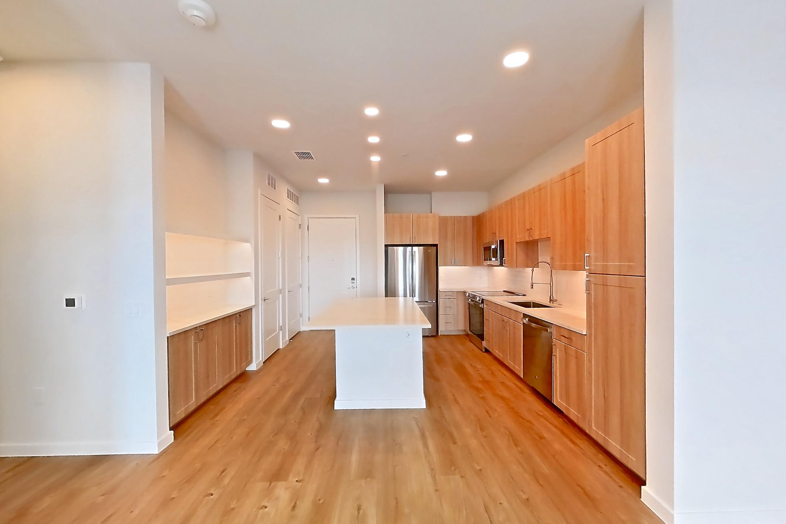 Living space with dishwasher, electric range, light countertops, light wood-finish flooring, oven/range, refrigerator, and stainless steel appliances, Apartment 459 at Lantower Bayside