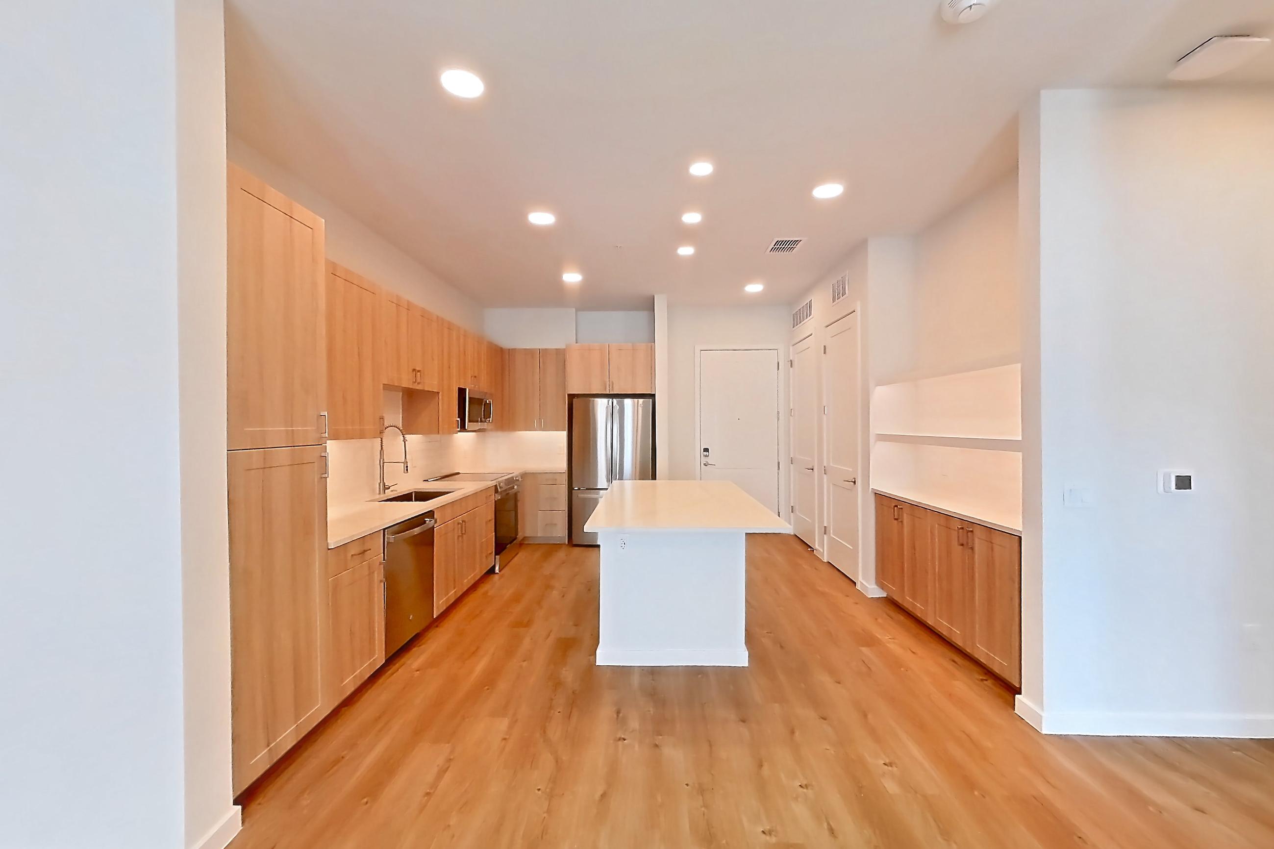 Living space with dishwasher, light countertops, light wood-finish flooring, oven/range, refrigerator, and stainless steel appliances, Apartment 460 at Lantower Bayside