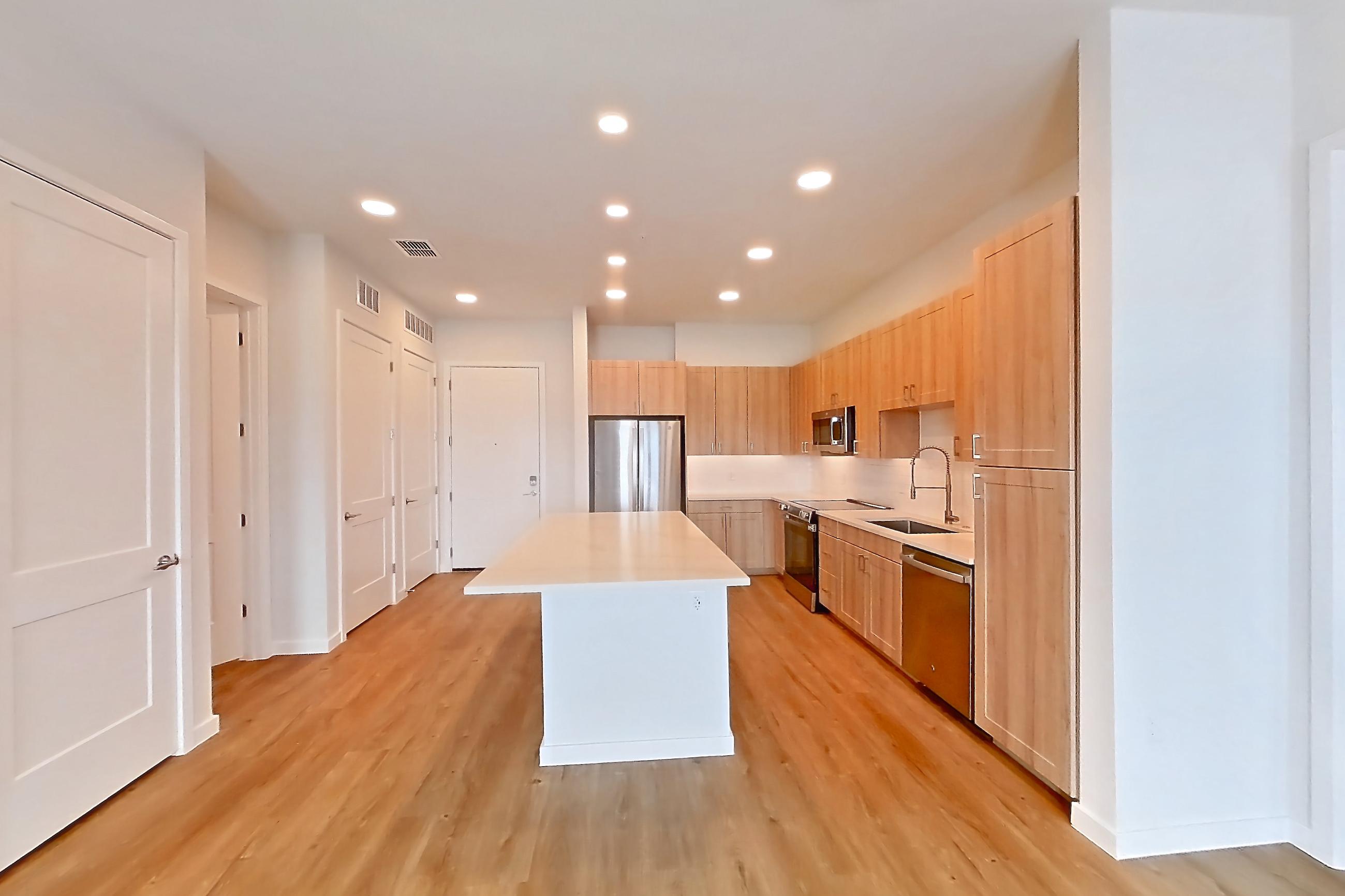 Living space with dishwasher, electric range, light countertops, light wood-finish flooring, oven/range, and stainless steel appliances, Apartment 463 at Lantower Bayside