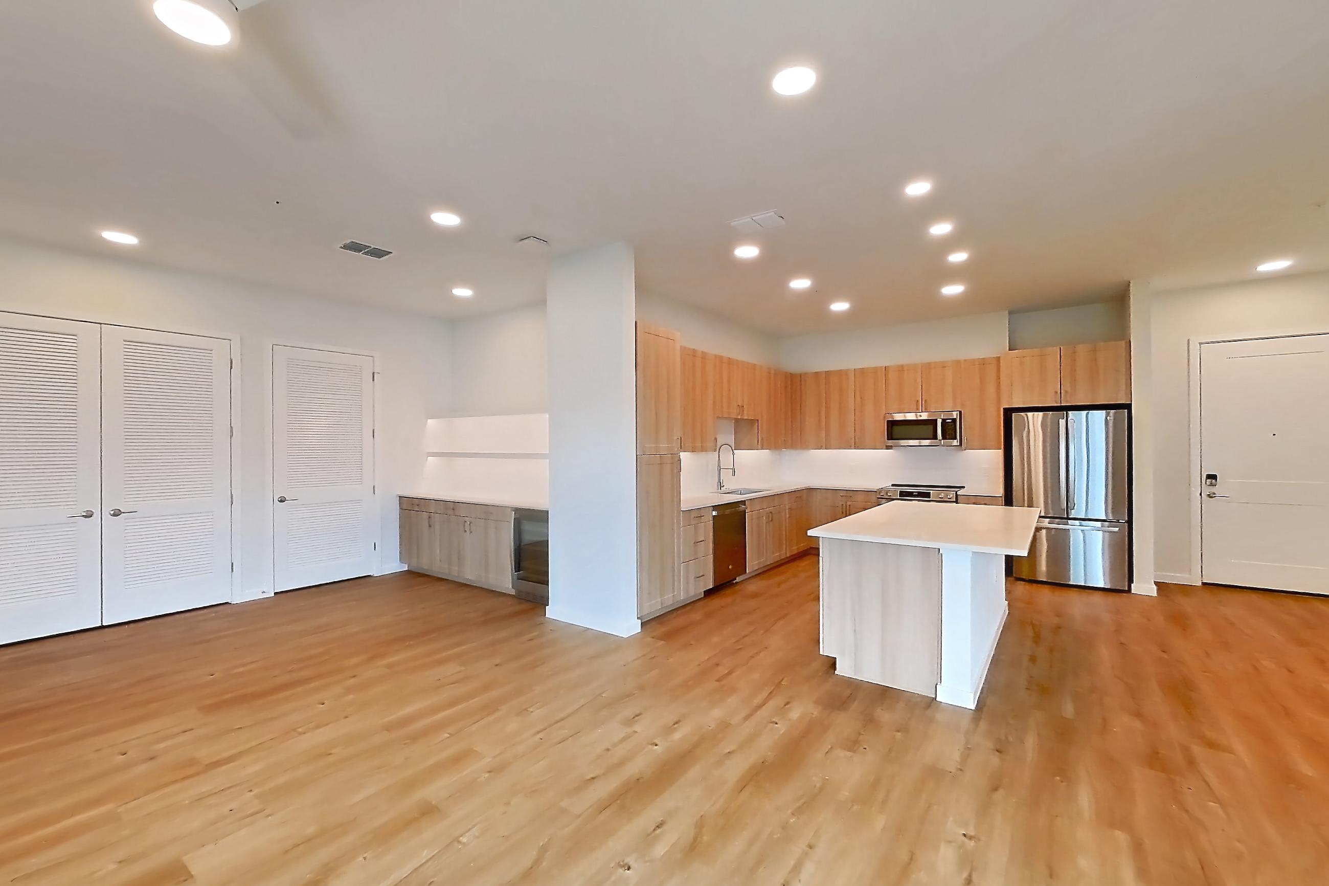 Living space with dishwasher, light countertops, light wood-finish flooring, oven/range, refrigerator, and stainless steel appliances, Apartment 464 at Lantower Bayside