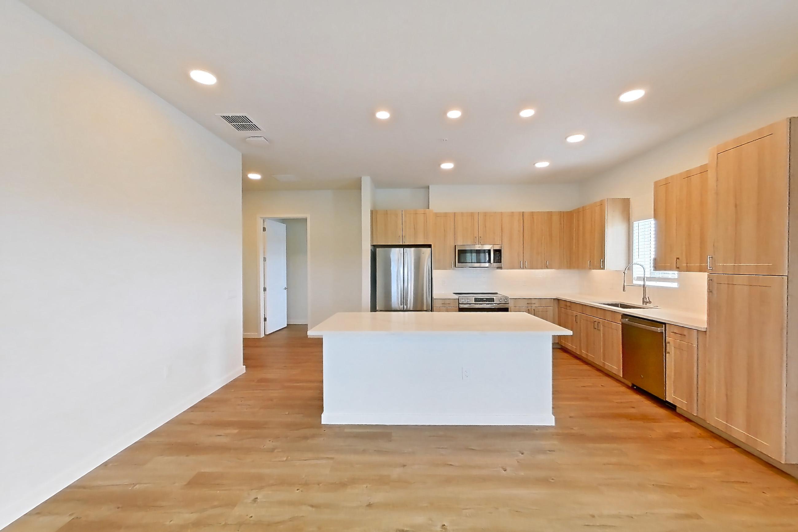 Living space with dishwasher, electric range, light countertops, light wood-finish flooring, oven/range, refrigerator, and stainless steel appliances, Apartment 465 at Lantower Bayside