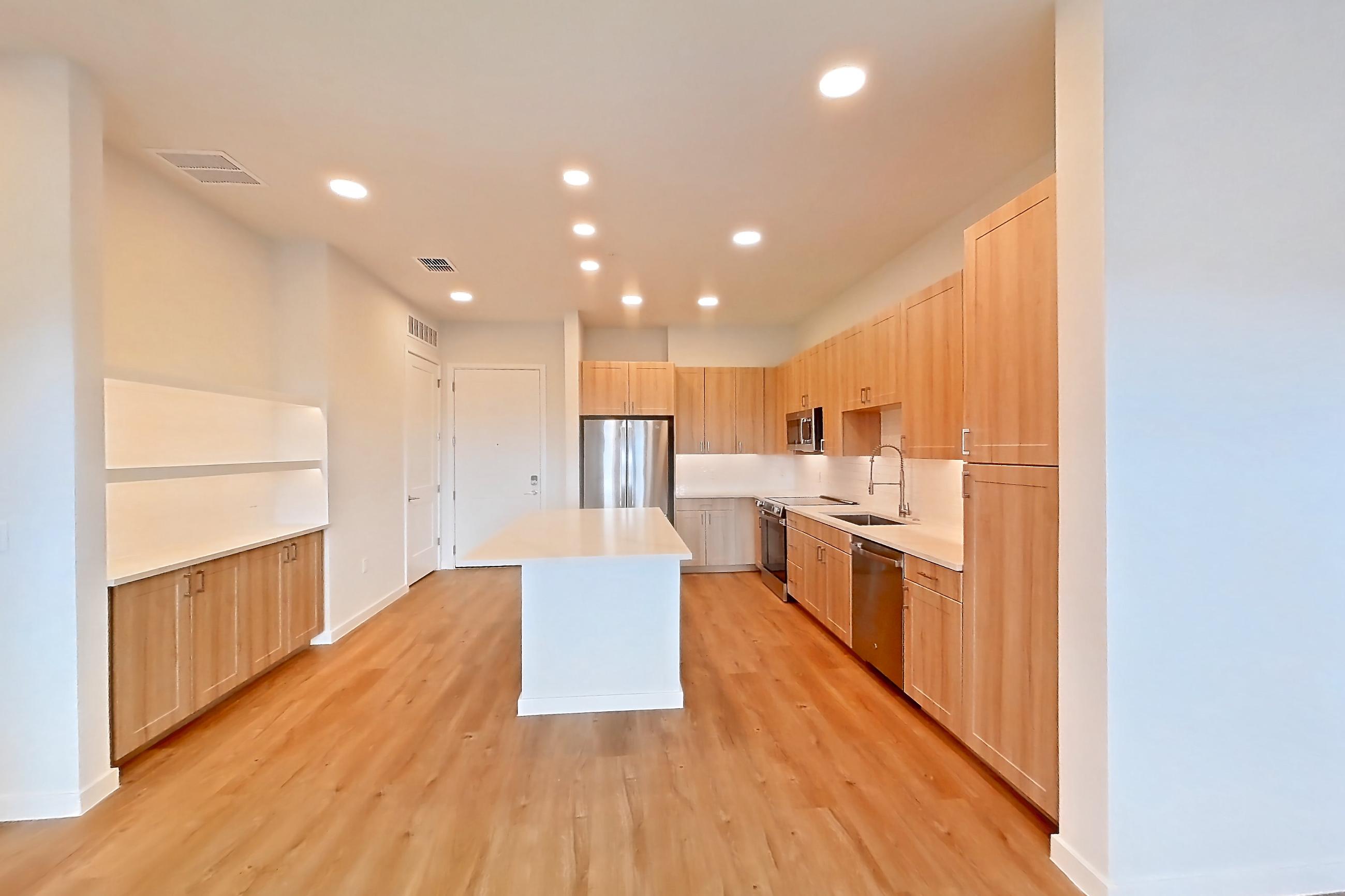 Living space with dishwasher, electric range, light countertops, light wood-finish flooring, oven/range, refrigerator, and stainless steel appliances, Apartment 469 at Lantower Bayside