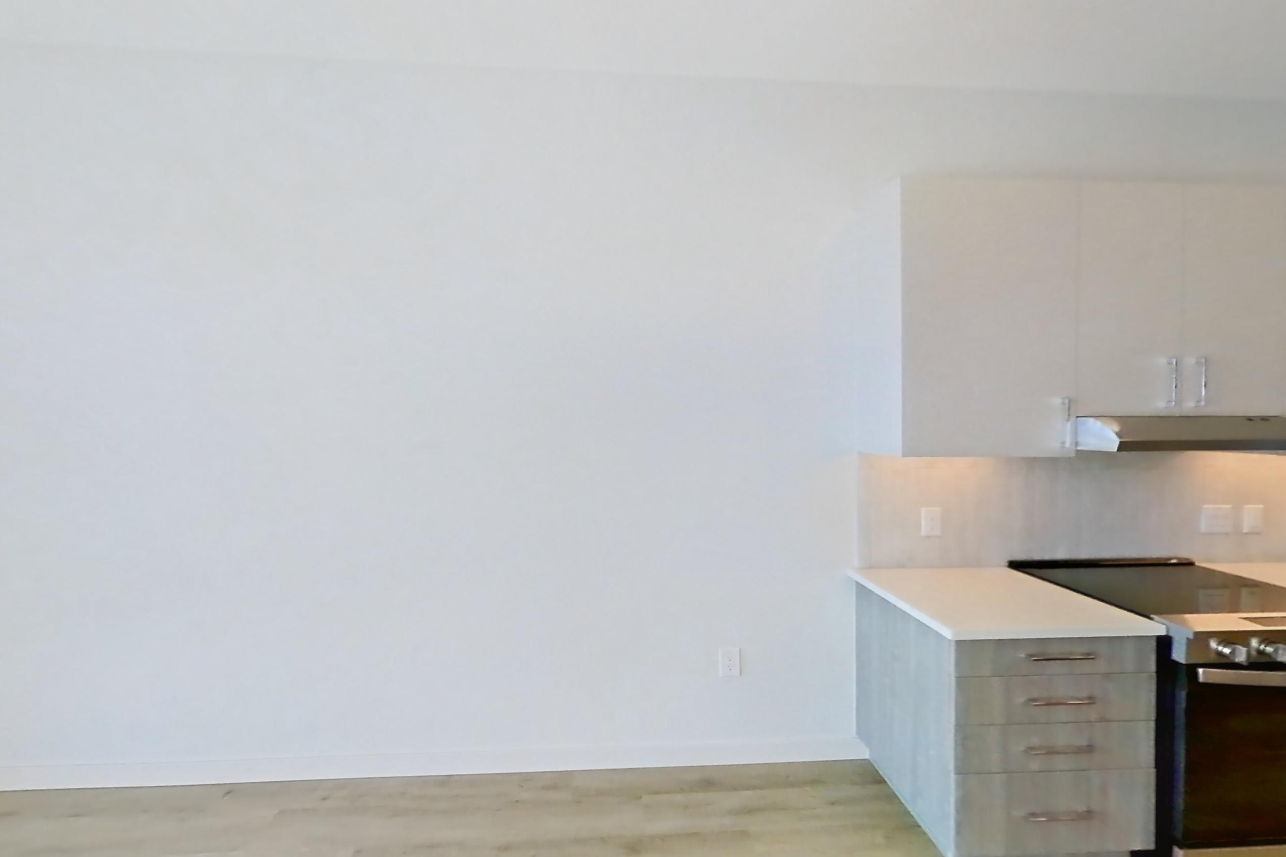 Living room with electric range, light countertops, light wood-finish flooring, oven/range, and stainless steel appliances, Apartment 411 at Gemma