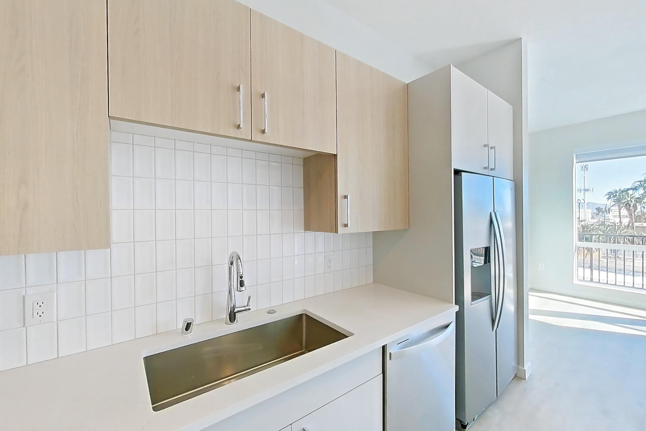 Kitchen with dishwasher, electric range, light stone countertops, light wood-finish flooring, microwave, oven/range, and stainless steel appliances, Apartment 307 at Gemma