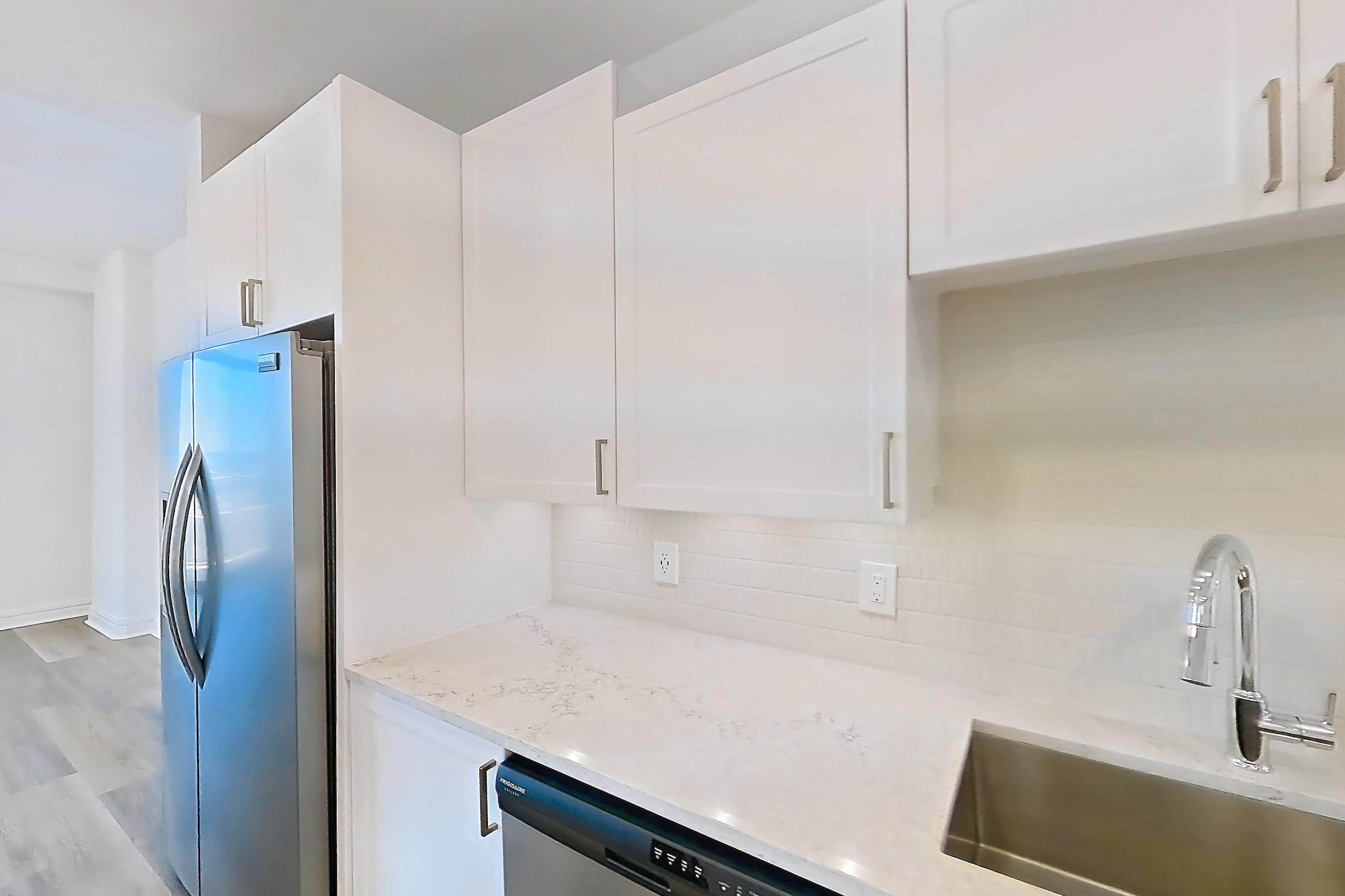 Kitchen with dishwasher, electric range, light countertops, light stone countertops, light wood-finish flooring, microwave, oven/range, and stainless steel appliances, Apartment 1804 at 1400HiLine