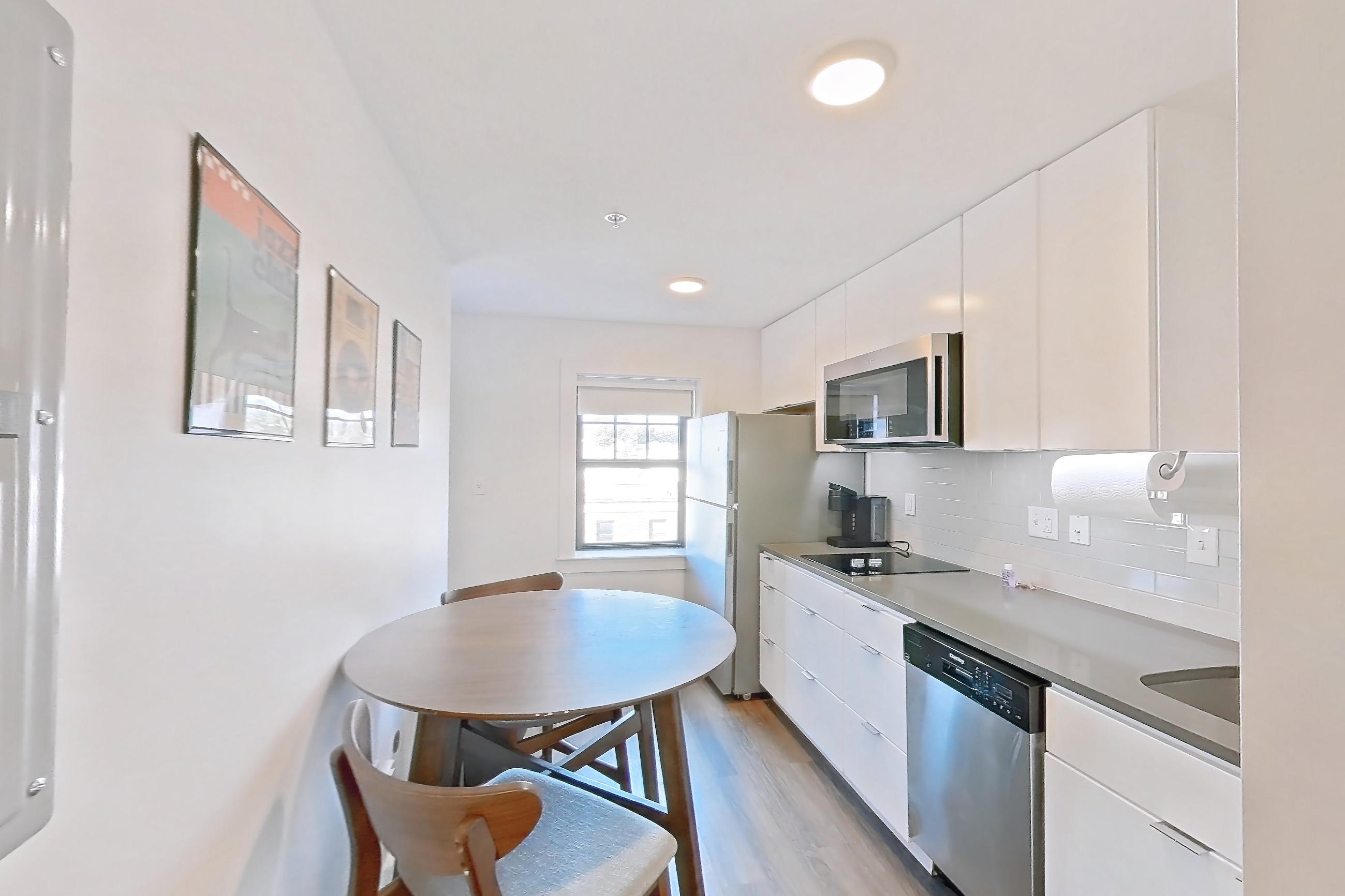 Living space with light wood-finish flooring, refrigerator, and white appliances, Apartment 1-415 at Netherland and Monarch